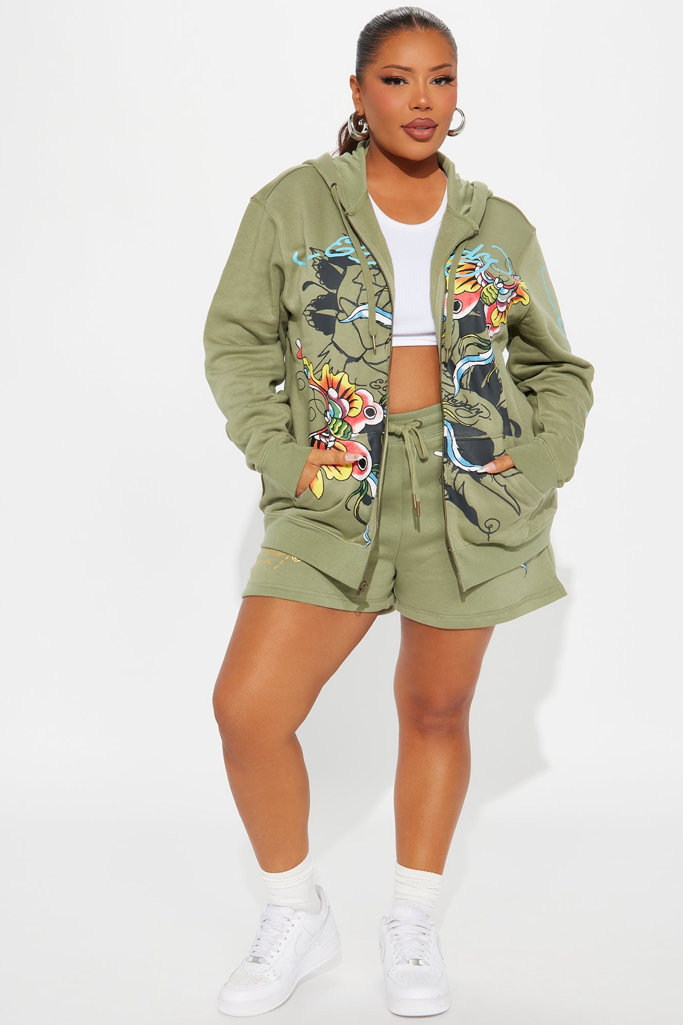 Women in olive Ed Hardy butterfly hoodie with floral designs and matching shorts for a stylish look