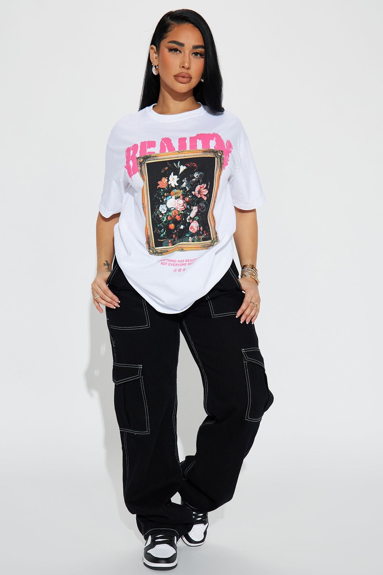 Model wearing an Eternal Beauty graphic t-shirt with a floral design and black cargo pants
