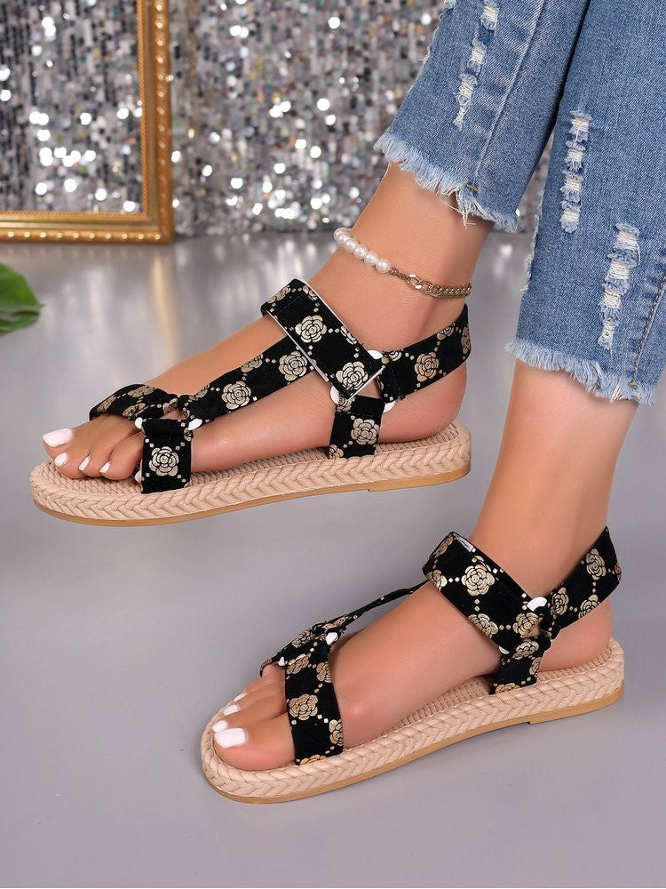 Wholesale7 black floral print flat sandals with beige braided sole worn with ripped jeans