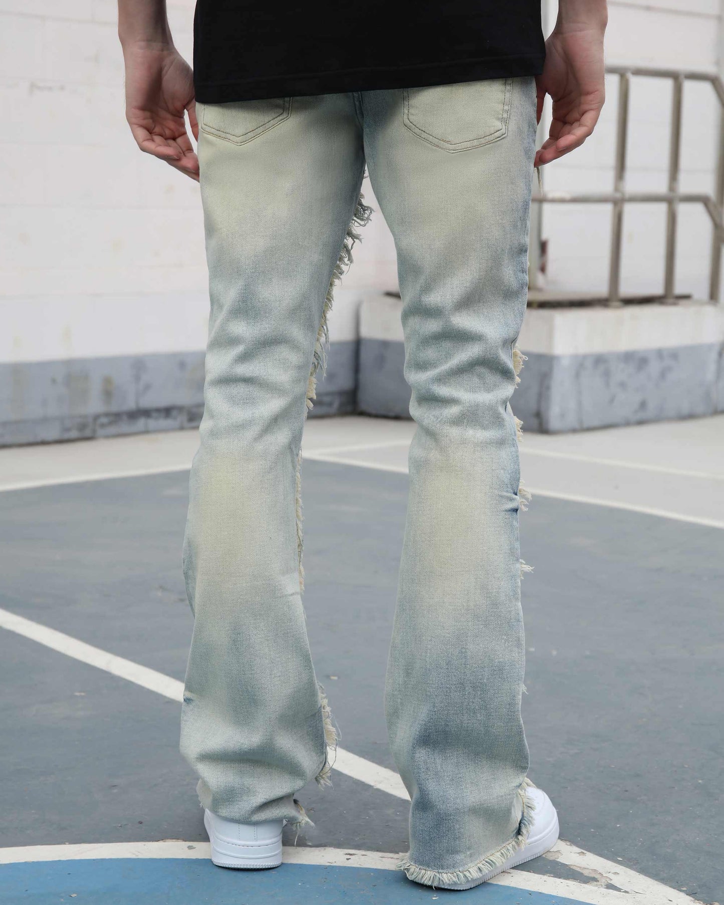 Logeqi light wash fringe flared jeans worn by model showing back view with distressed details