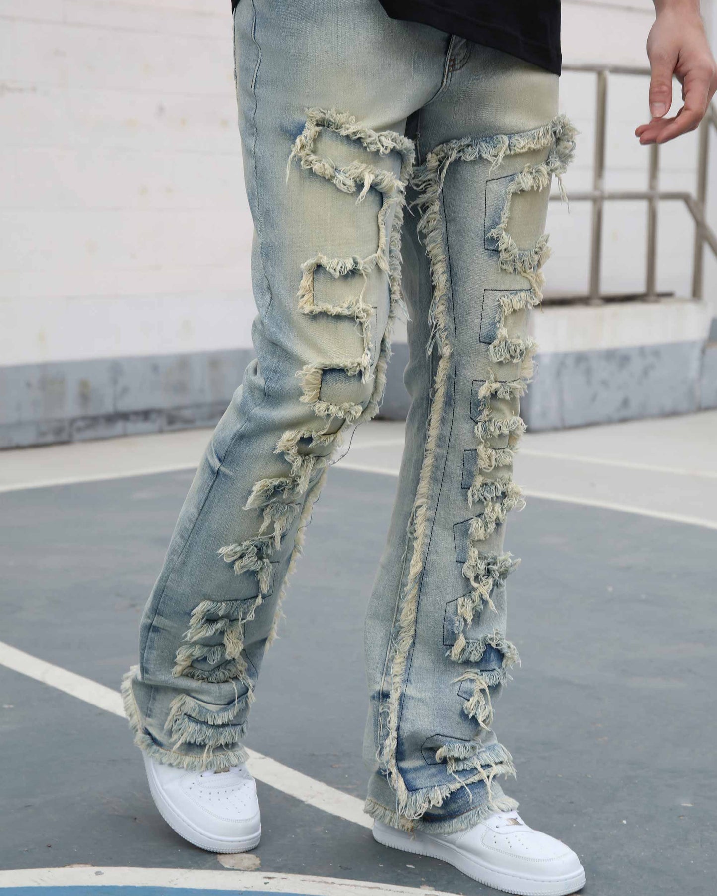 Logeqi fringe flared jeans in light blue denim with distressed fringes down the legs and white sneakers