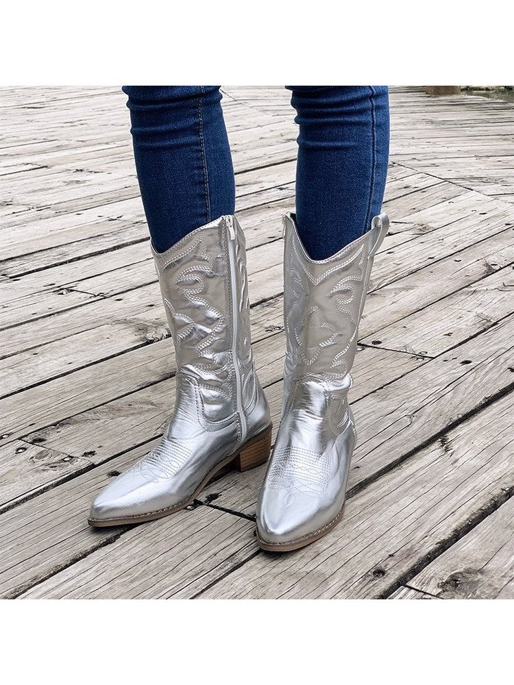 Wholesale7 glossy pointed toe boots in metallic silver worn with blue jeans on wooden floor