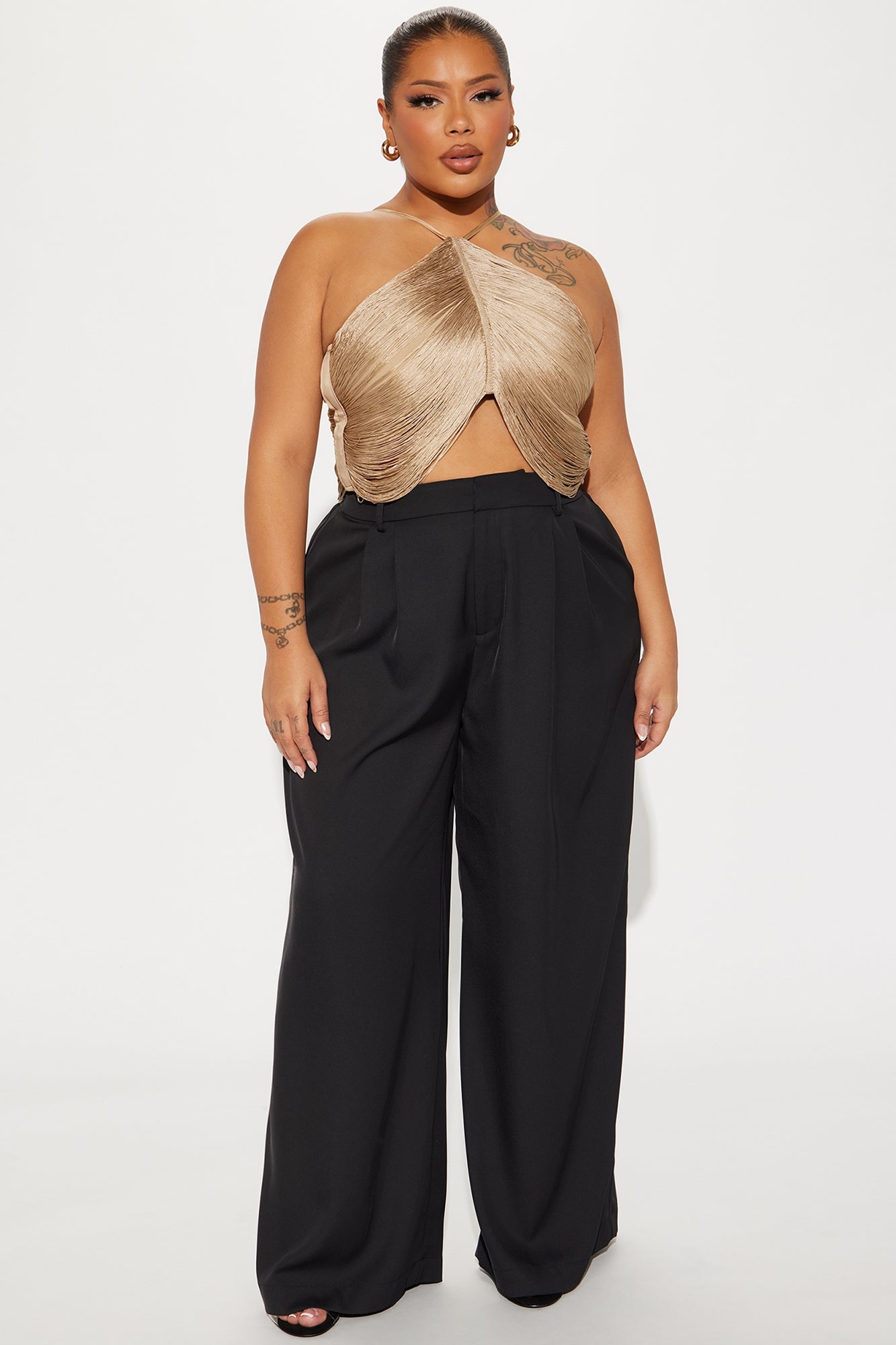 Fashion Nova gold fringe crop top styled with high-waisted black trousers for a chic look