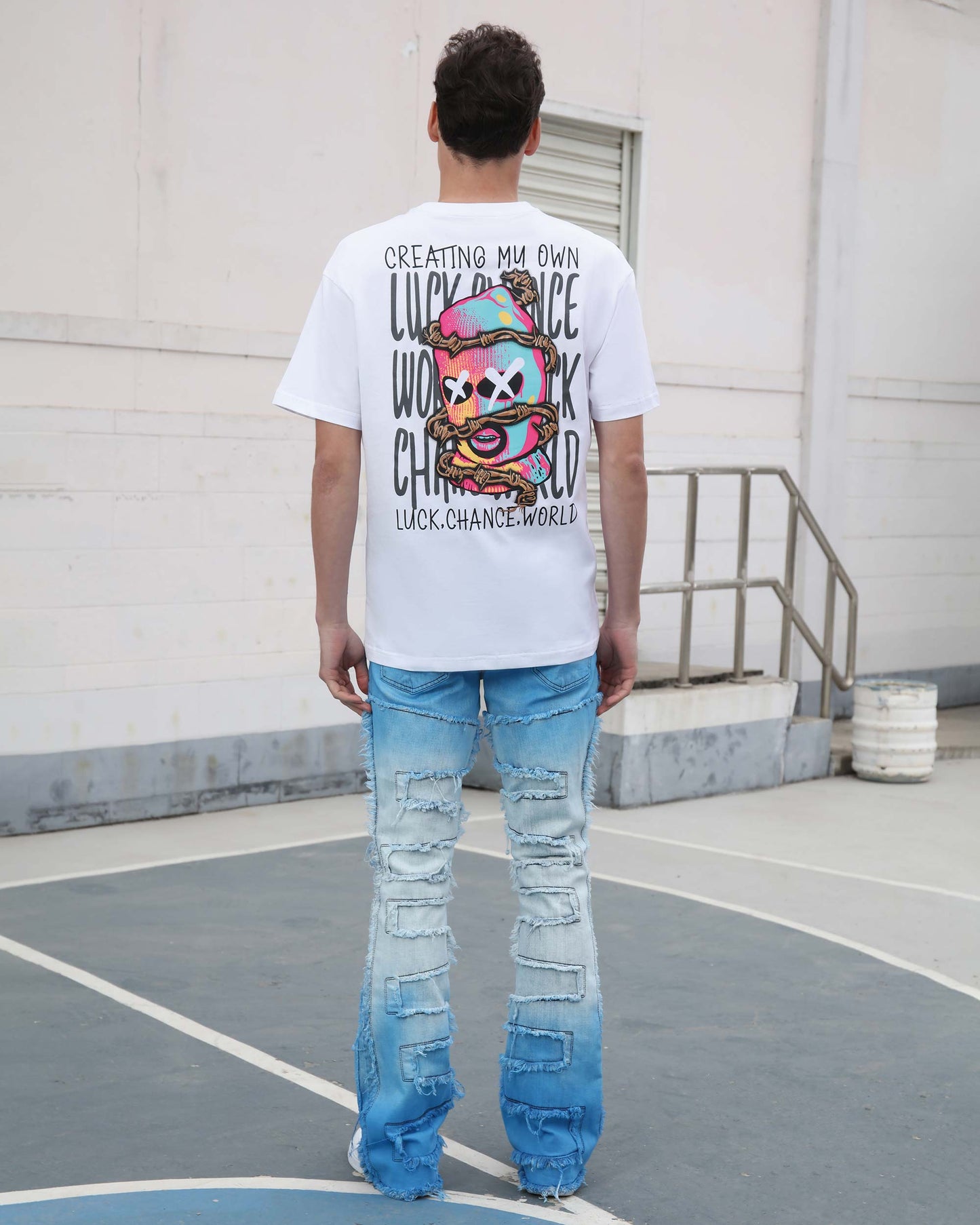 Logeqi gradient blue flare jeans with patch detailing worn by a man standing outdoors