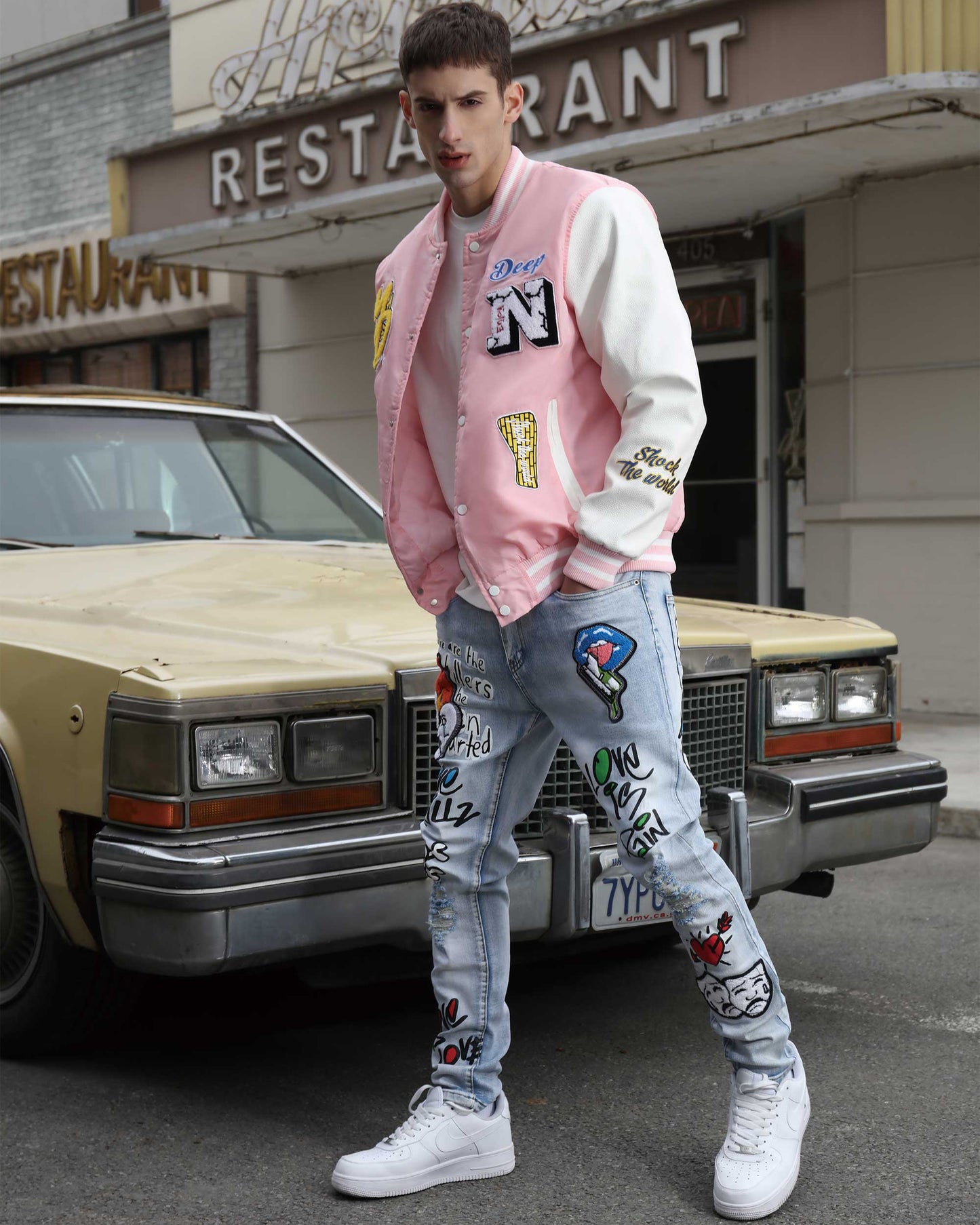 Logeqi graffiti painted jeans with vibrant designs worn by model outside a restaurant