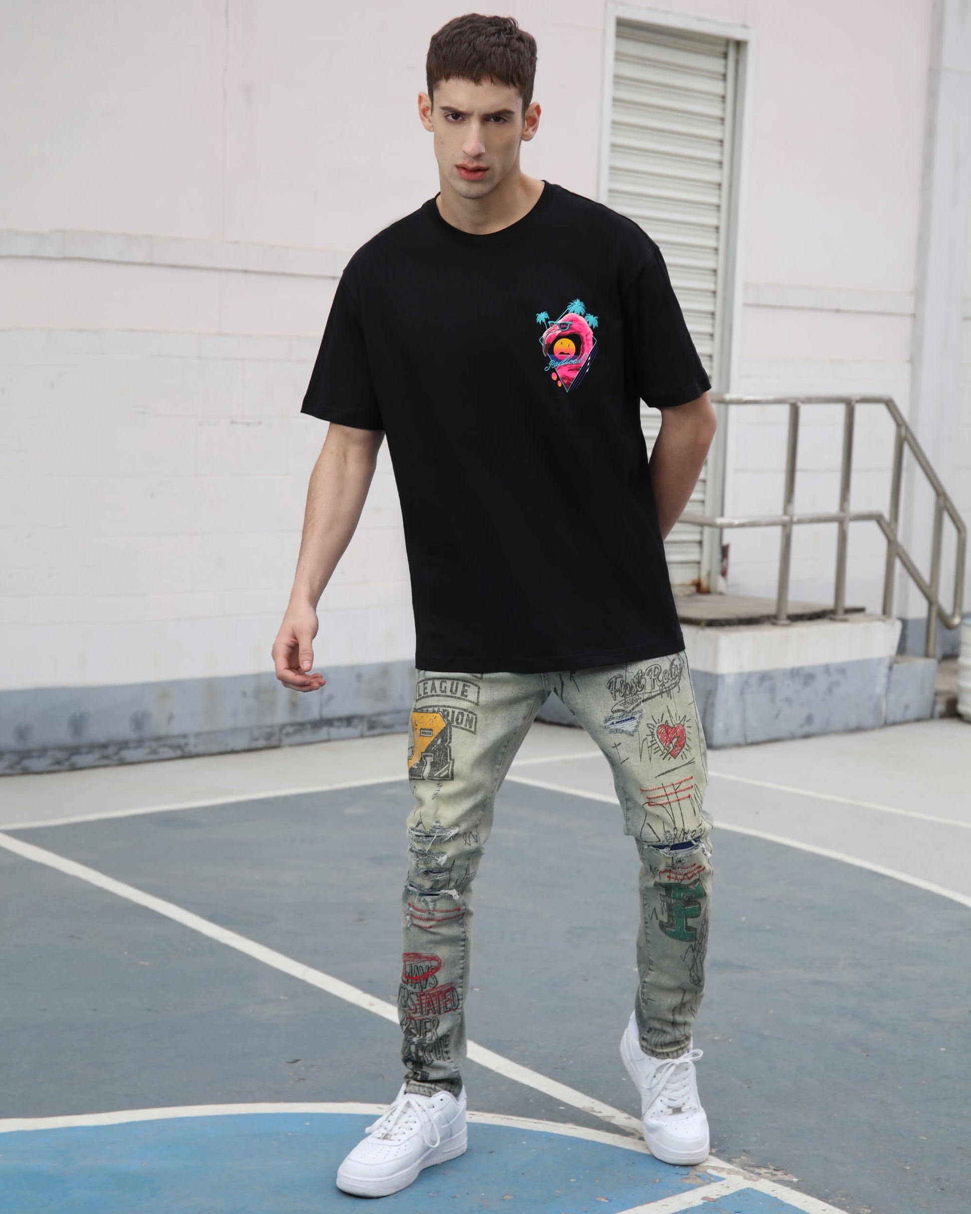Logeqi graffiti ripped jeans with colorful designs worn by a model in a casual setting