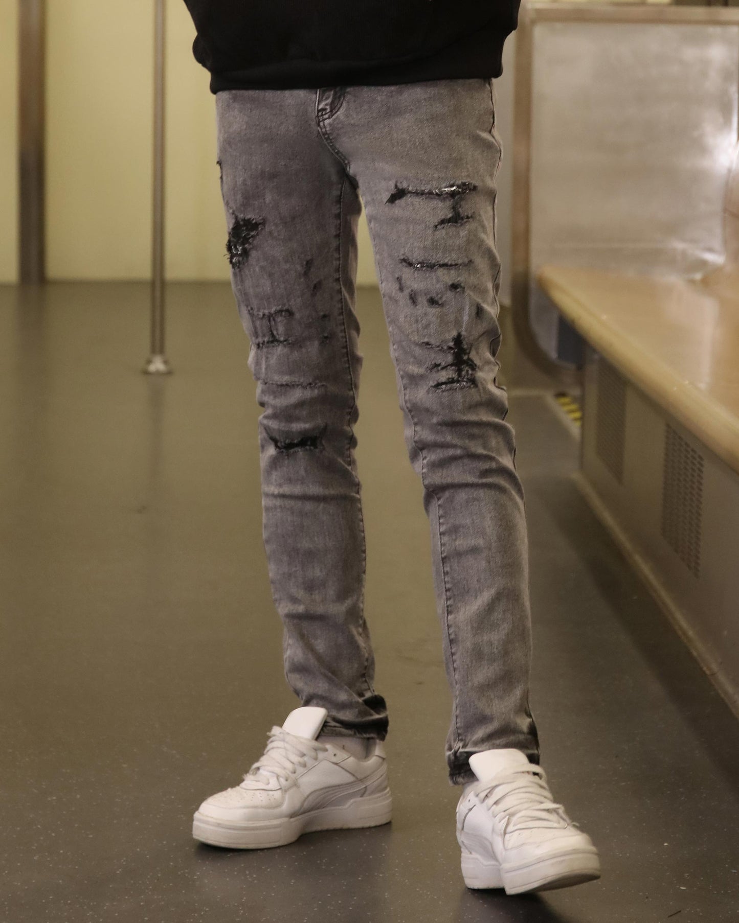 Logeqi gray ripped jeans men styled with white sneakers in an indoor setting