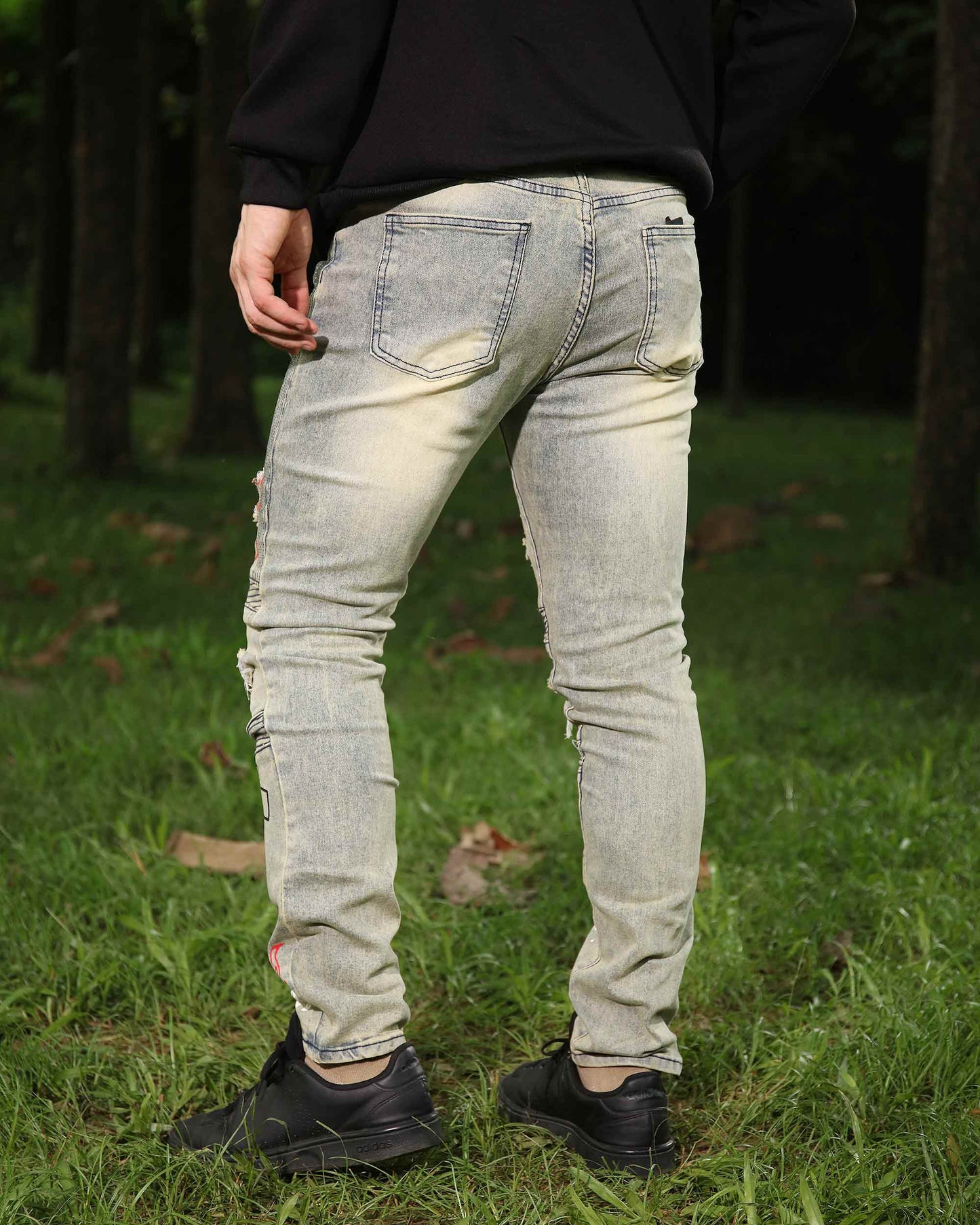 Back view of Logeqi hip-hop distressed jeans in light wash with a fitted design and unique detailing