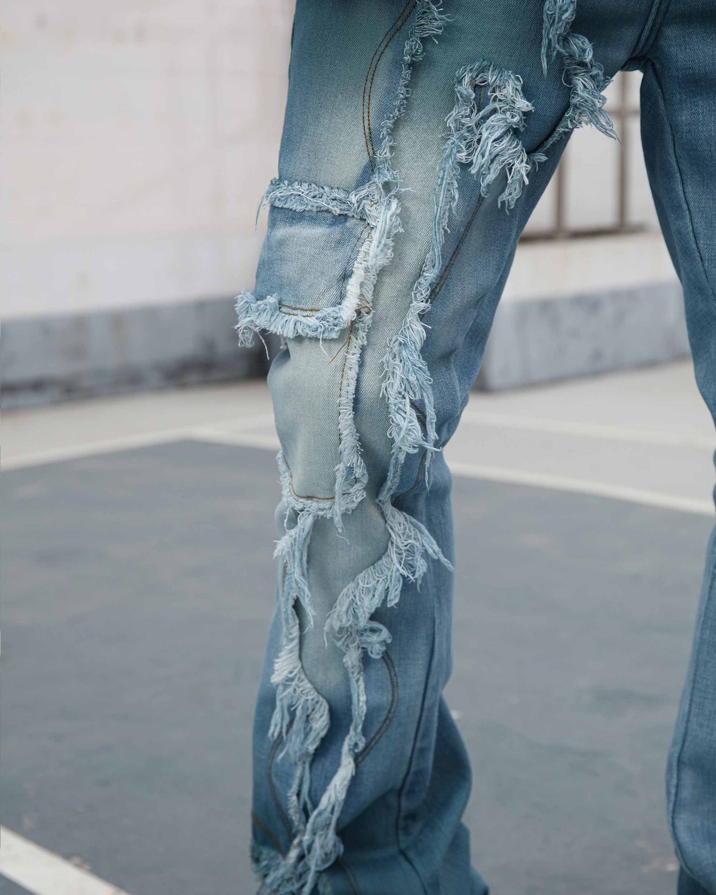 Logeqi irregular blue stacked jeans with distressed detailing and frayed edges