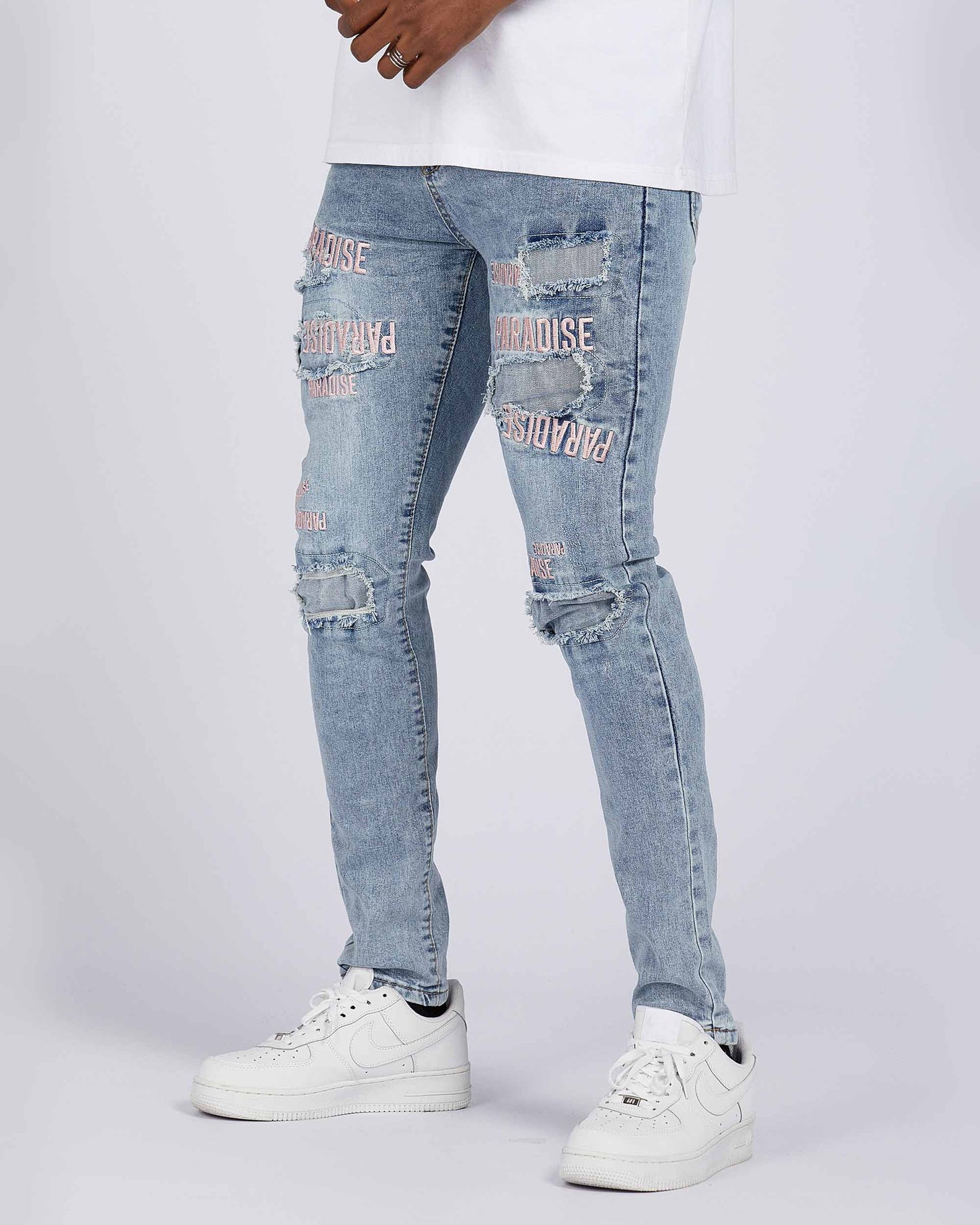Logeqi light wash blue ripped jeans with stylish distressing and pink graphic details