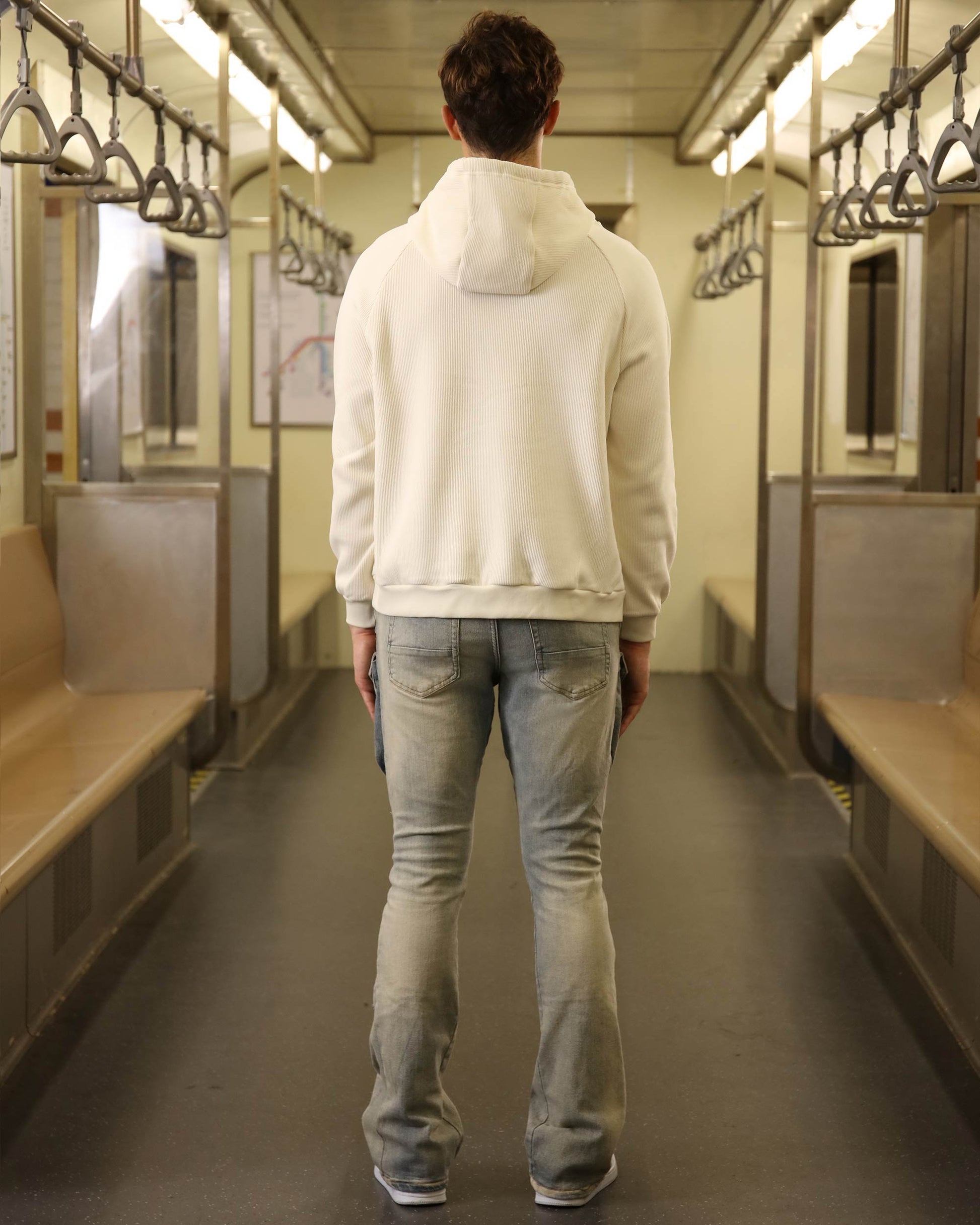Logeqi light wash cargo jeans displayed on a person standing in a subway train interior