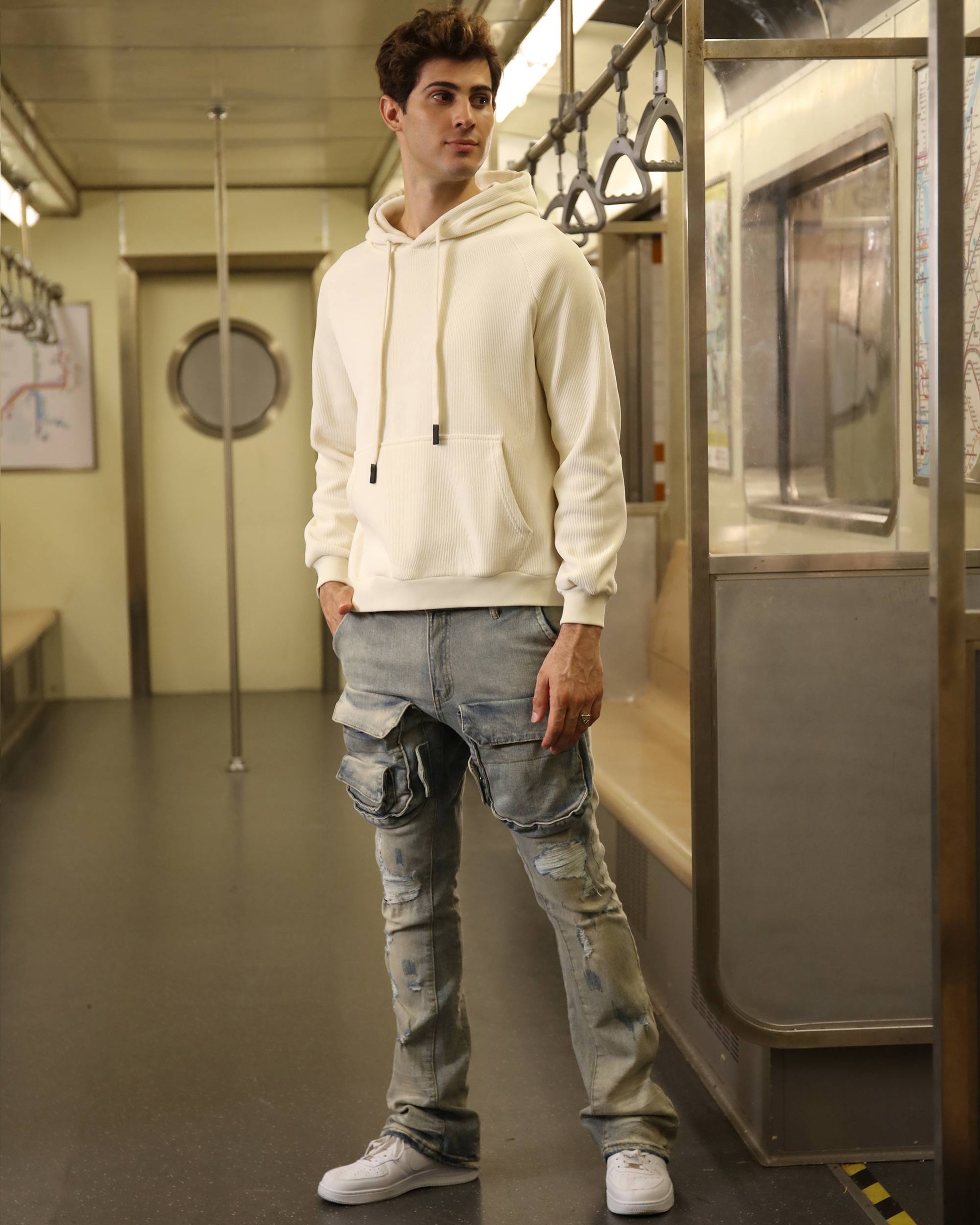 Logeqi light wash cargo jeans worn by a model in a subway setting, featuring stylish pockets and a relaxed fit