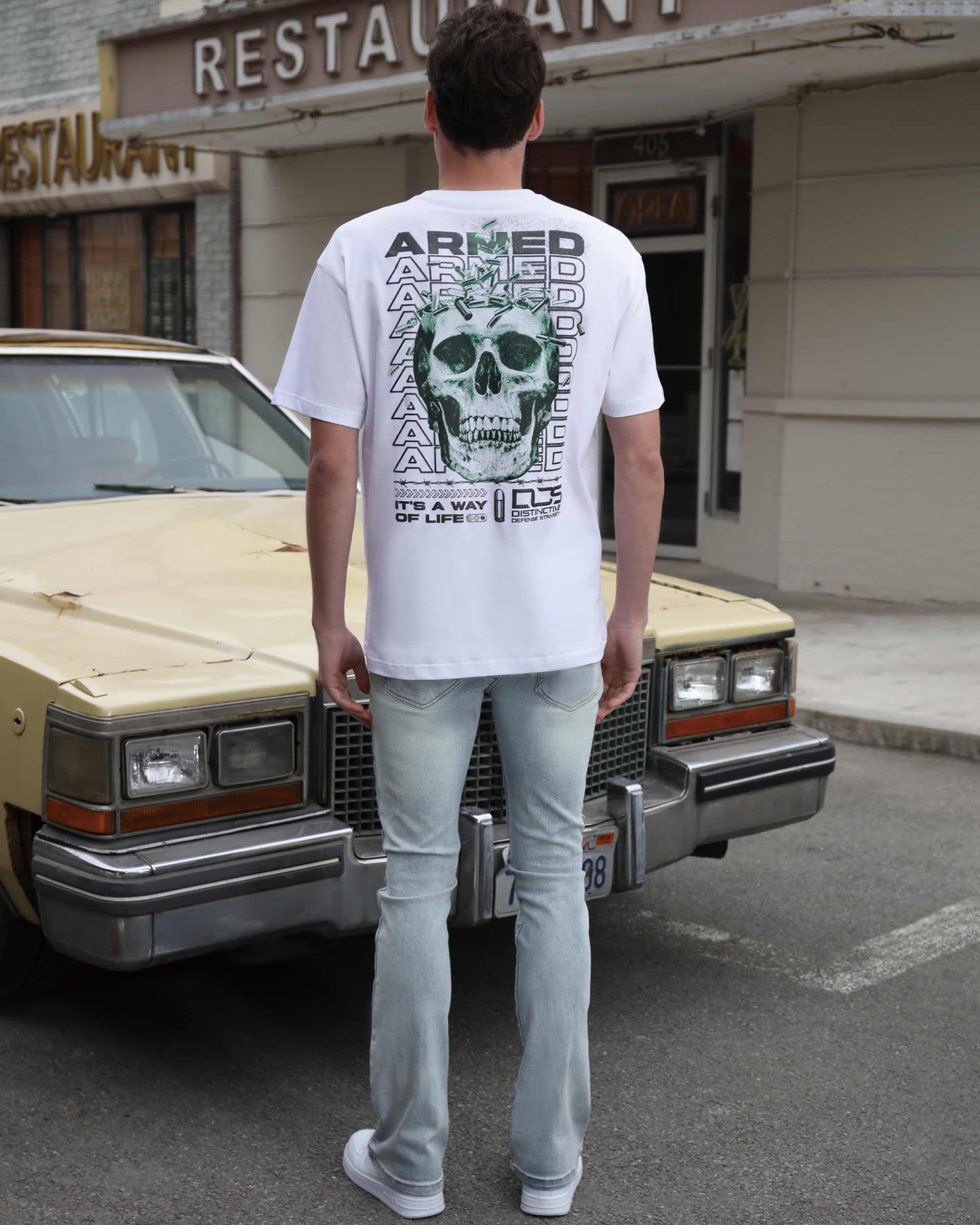 Light wash flared jeans by Logeqi paired with a graphic skull t-shirt for a casual look