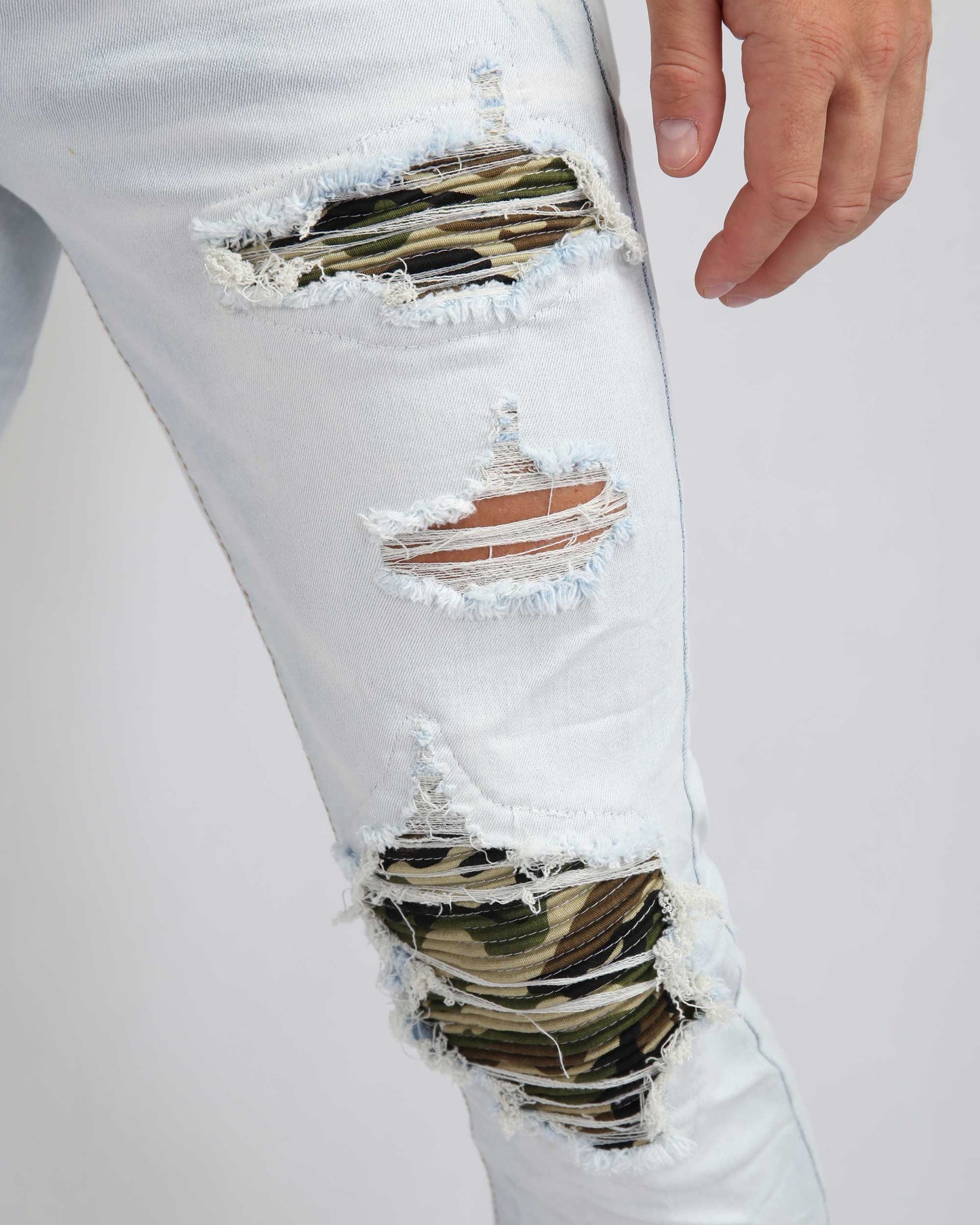 Logeqi light wash ripped jeans featuring unique camo patches and distressed detailing
