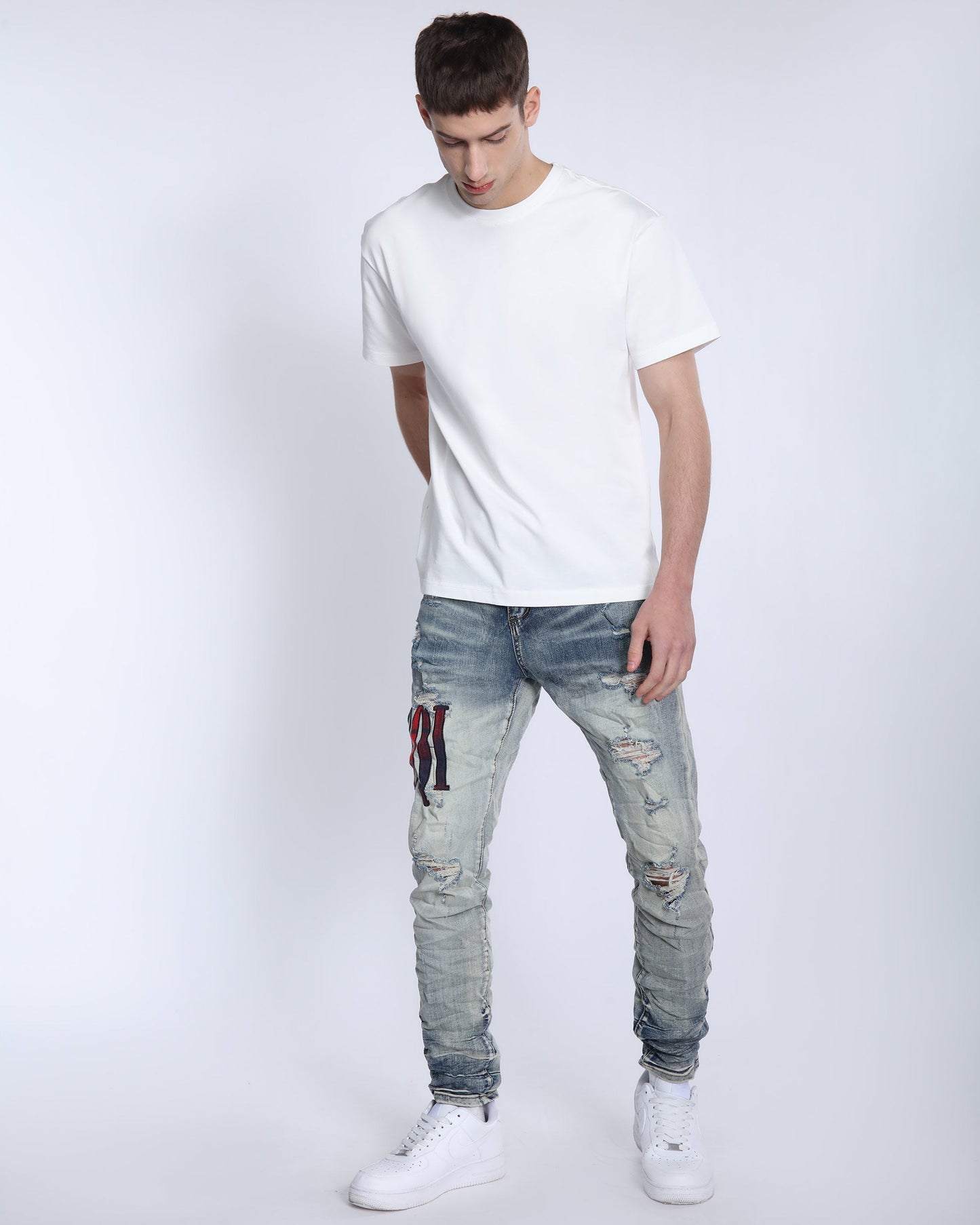 Logeqi light washed ripped jeans styled with a white t-shirt for a casual look