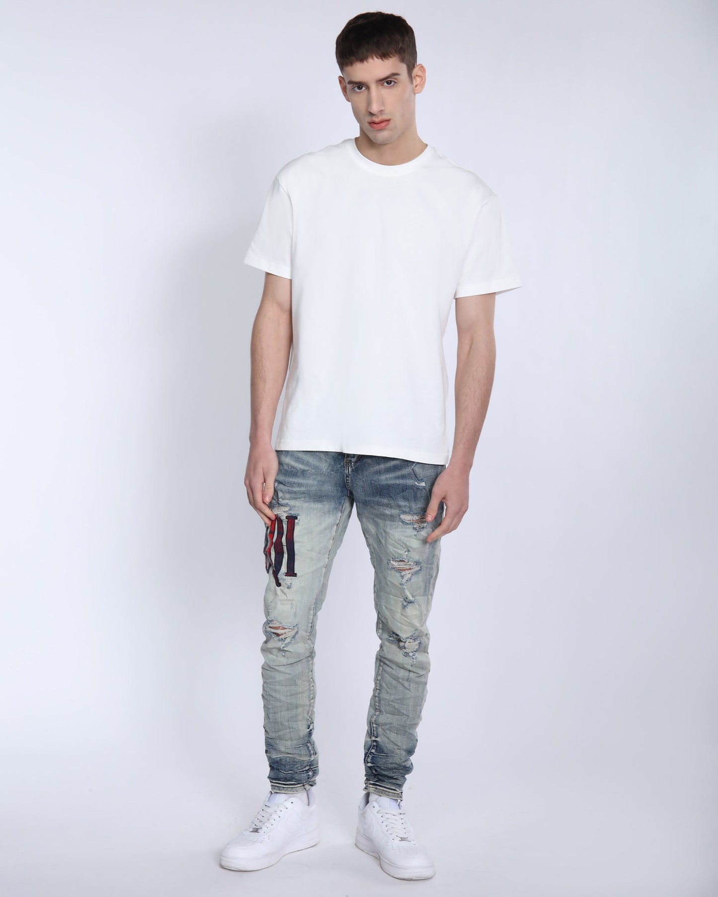 Men's Logeqi light washed ripped jeans styled with a white t-shirt and sneakers