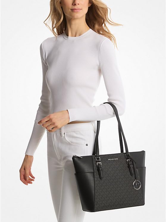 Stylish woman holding a black Michael Kors Charlotte Saffiano leather handbag with dual handles