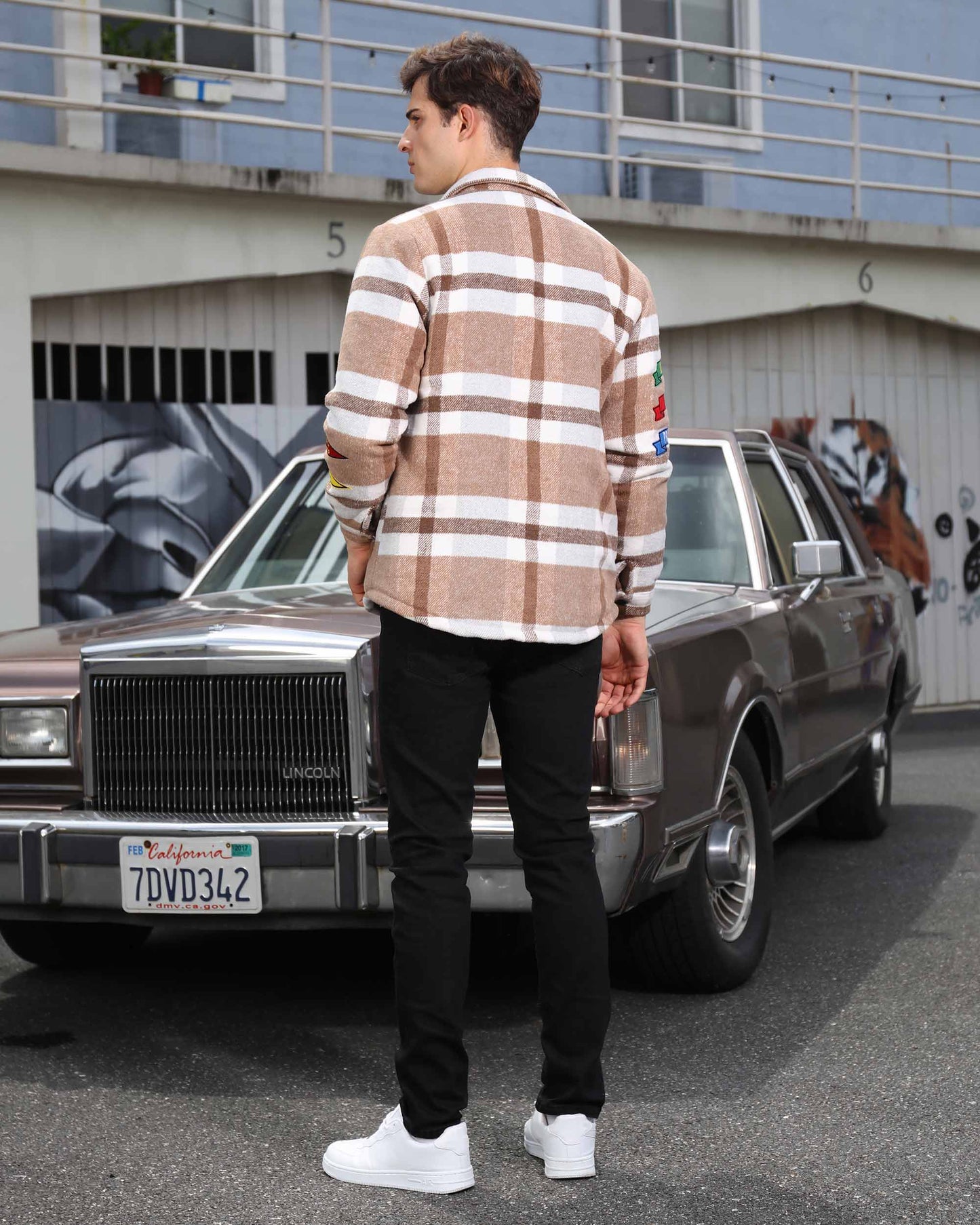 Back view of a man wearing a Logeqi modern plaid moto jacket with brown and white checks