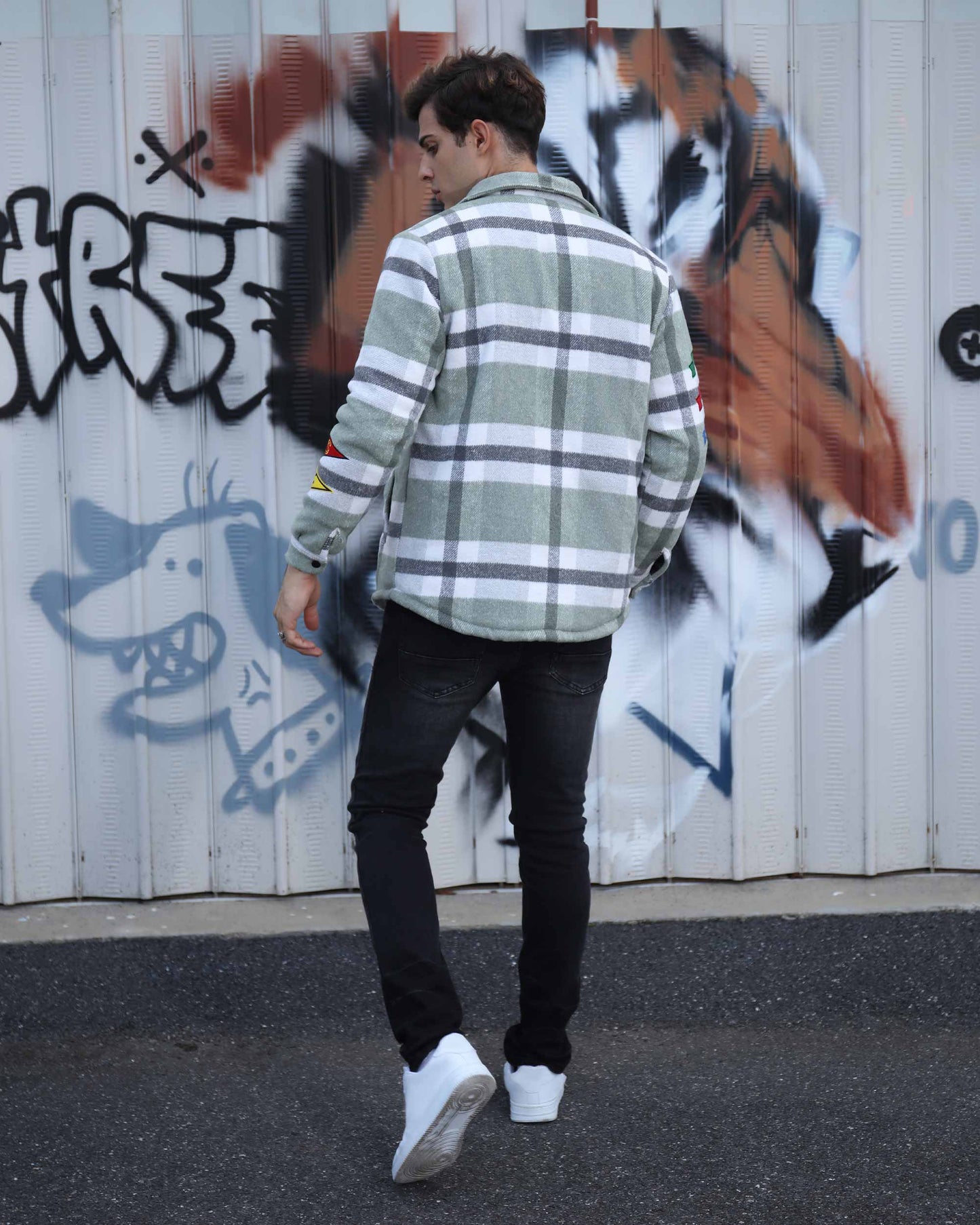 Man wearing Logeqi modern plaid moto jacket with green and white check pattern styled with black jeans and white shoes
