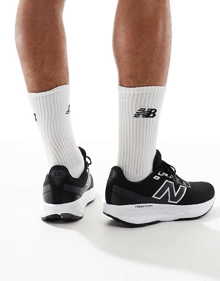Men wearing New Balance 520 running shoes in black and white with cushioned soles and white socks