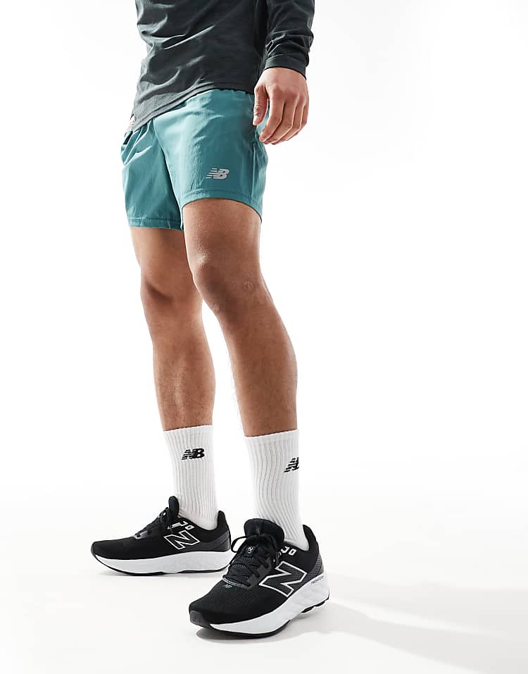 Men wearing New Balance 520 running shoes in black paired with white socks and teal shorts