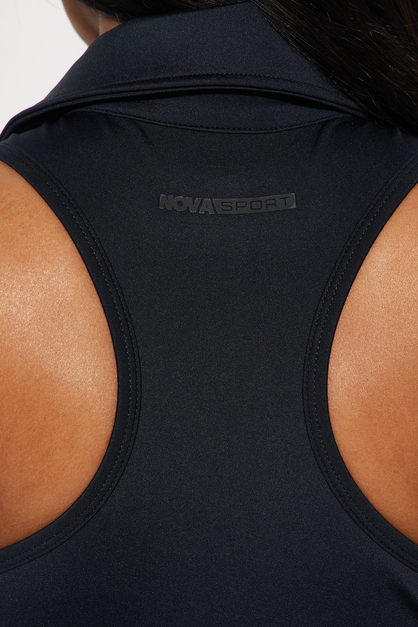 Close-up of the Nova Sport logo on the back of a black active dress for women