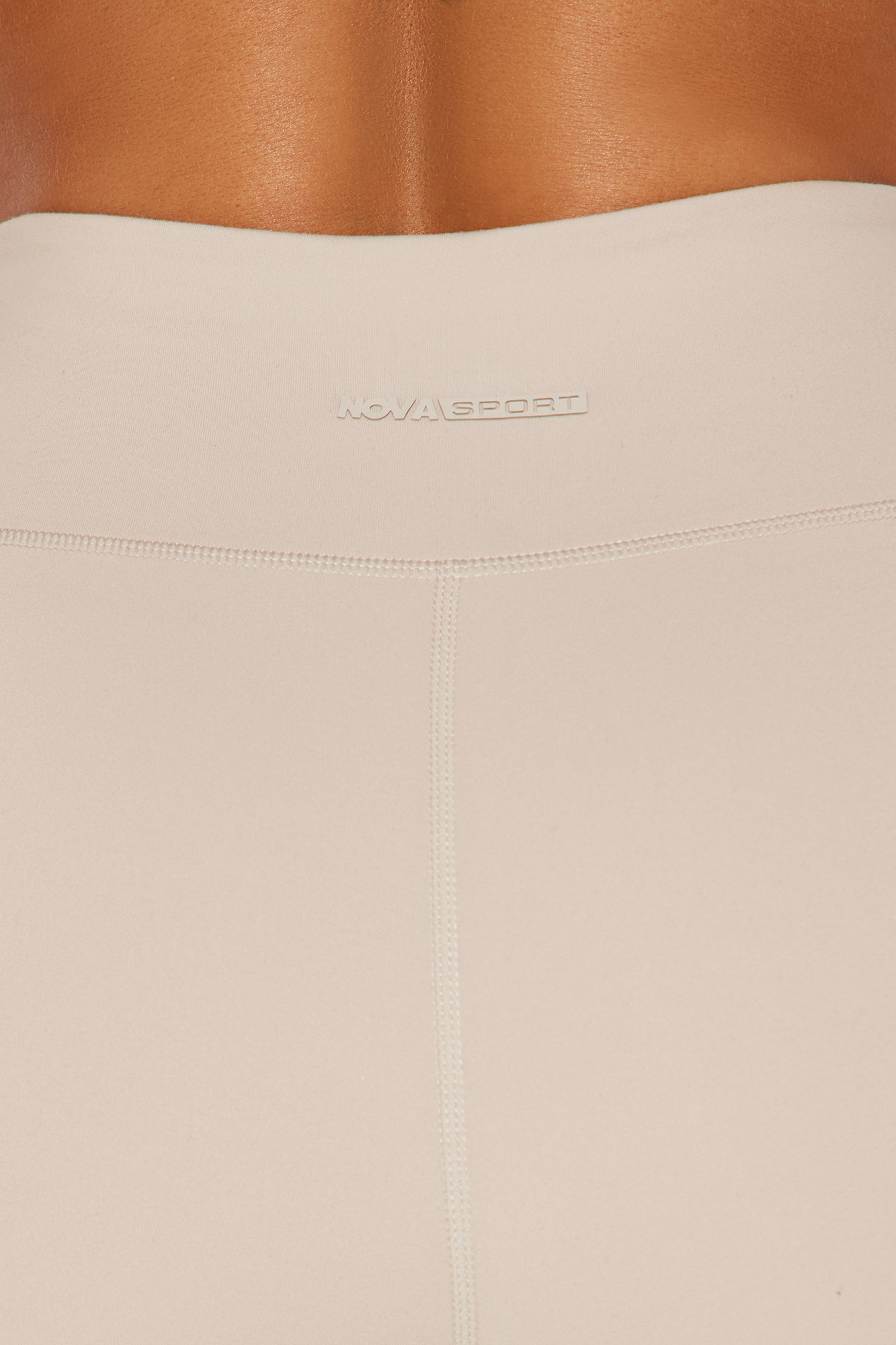Close-up of Fashion Nova Nova Sport super soft active capri in a light beige color showcasing the waistband