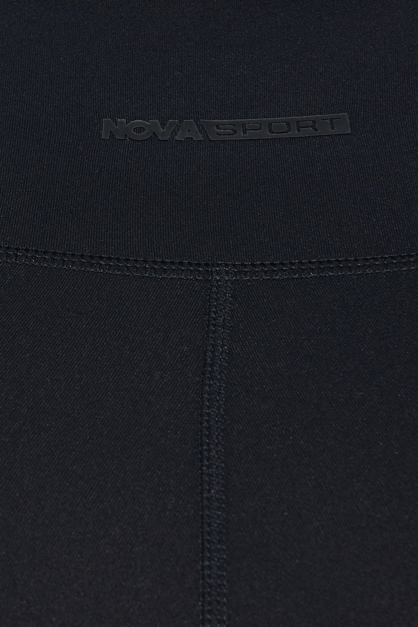 Close-up of Nova Sport logo on super soft black capri leggings for comfortable workouts