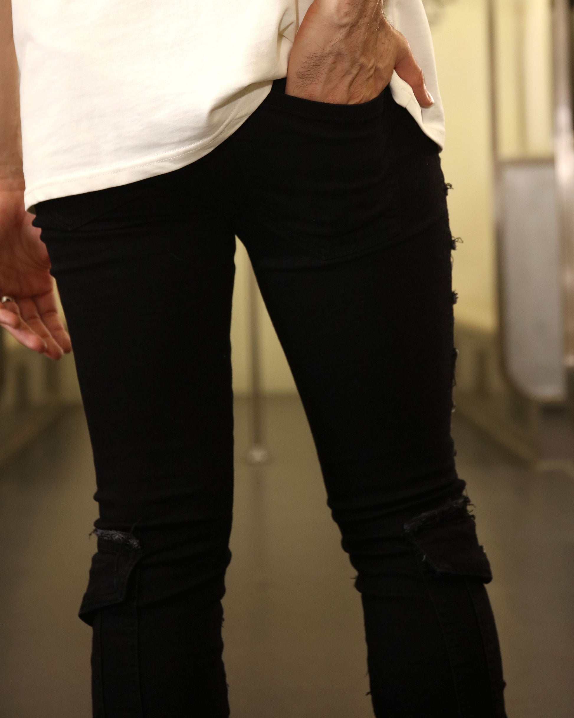 Logeqi raw edge black jeans with slim fit and distressed details worn with white shirt