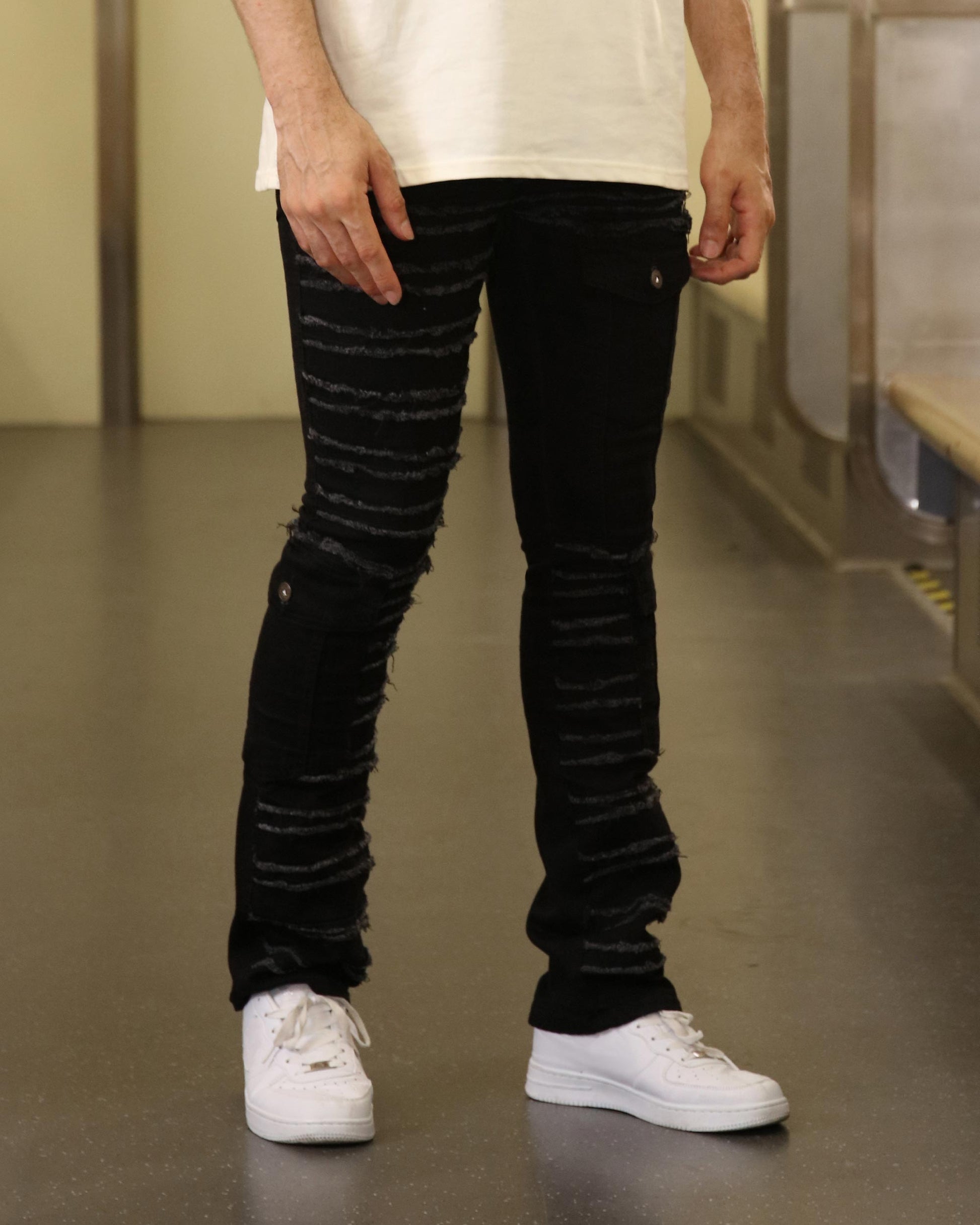 Logeqi raw edge black jeans with distressed striped design worn with white sneakers