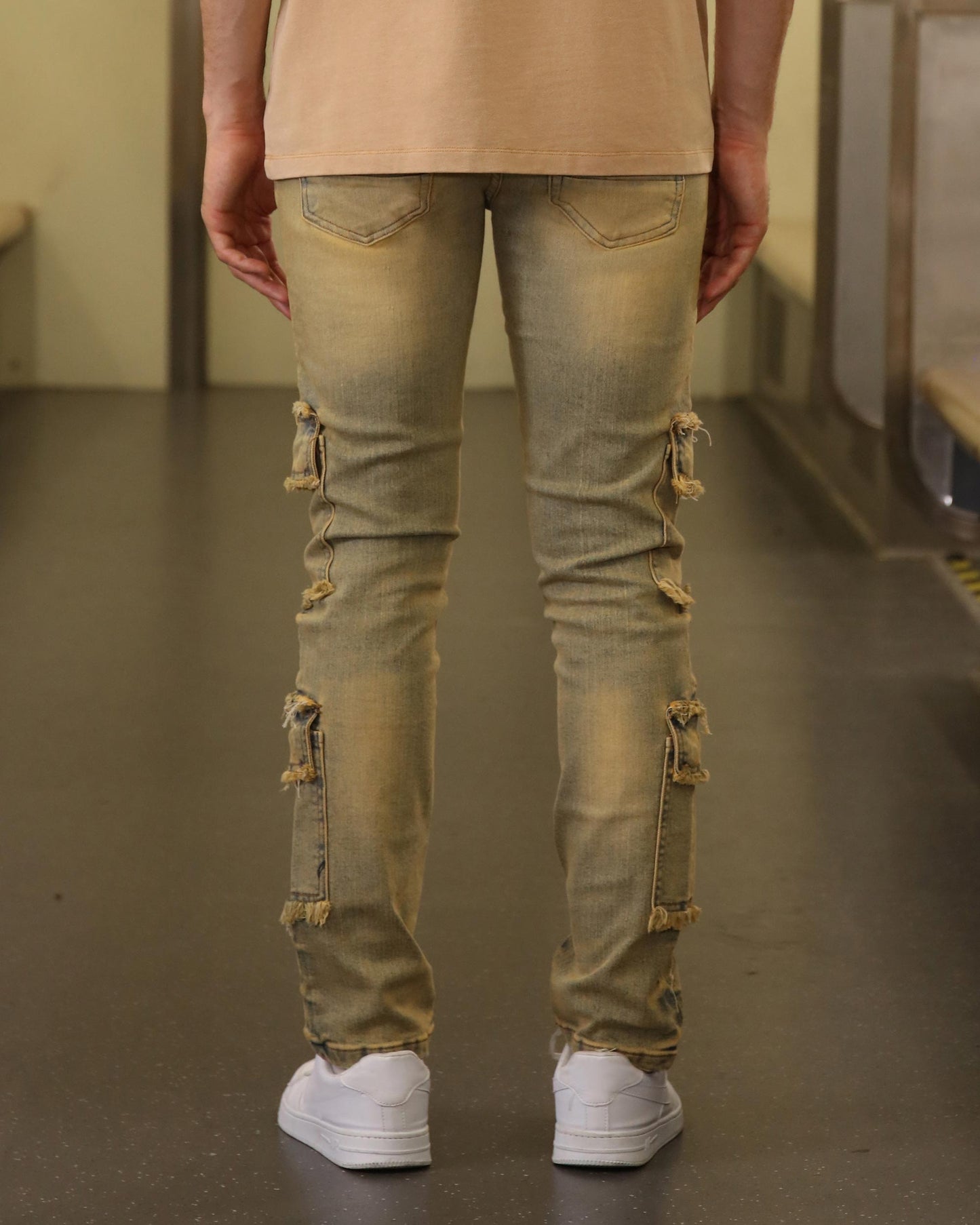 Logeqi raw edge brown jeans with distressed details and ripped patches on the back of legs