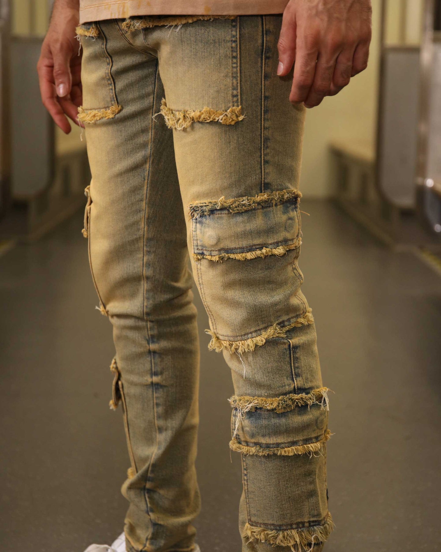 Logeqi raw edge brown jeans with distressed patches and frayed detailing on legs