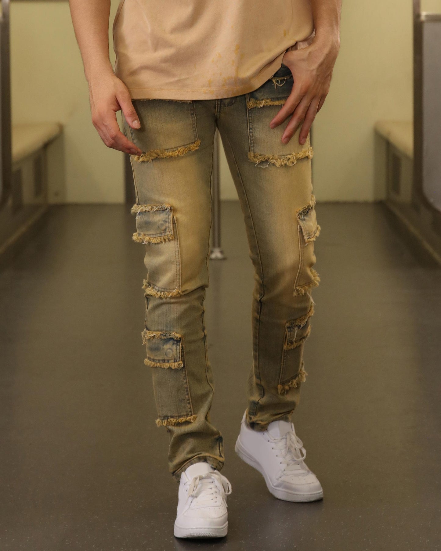 Logeqi raw edge brown jeans with distressed patches and frayed detailing worn with white sneakers