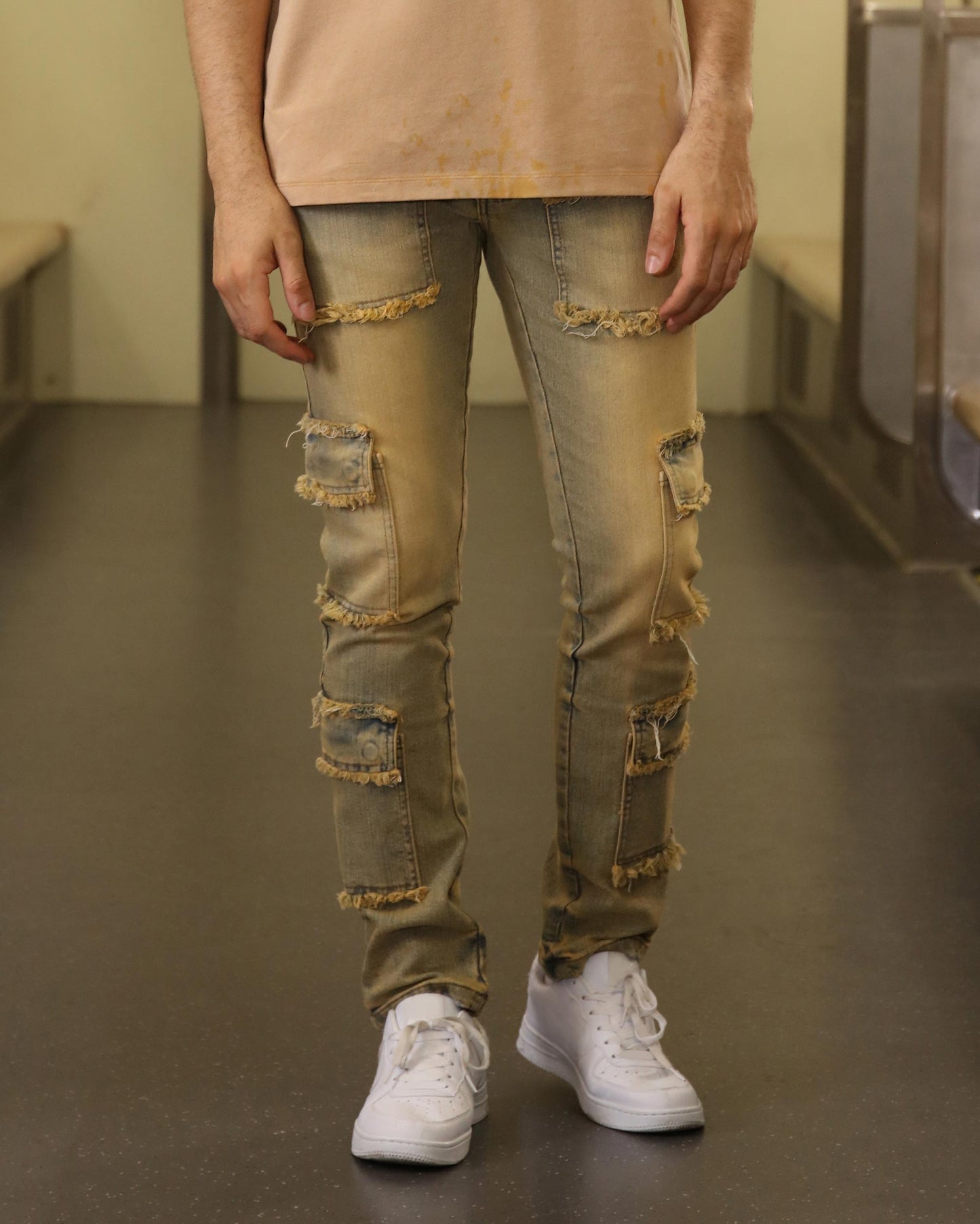 Logeqi raw edge brown jeans with distressed patches and frayed details worn with white sneakers