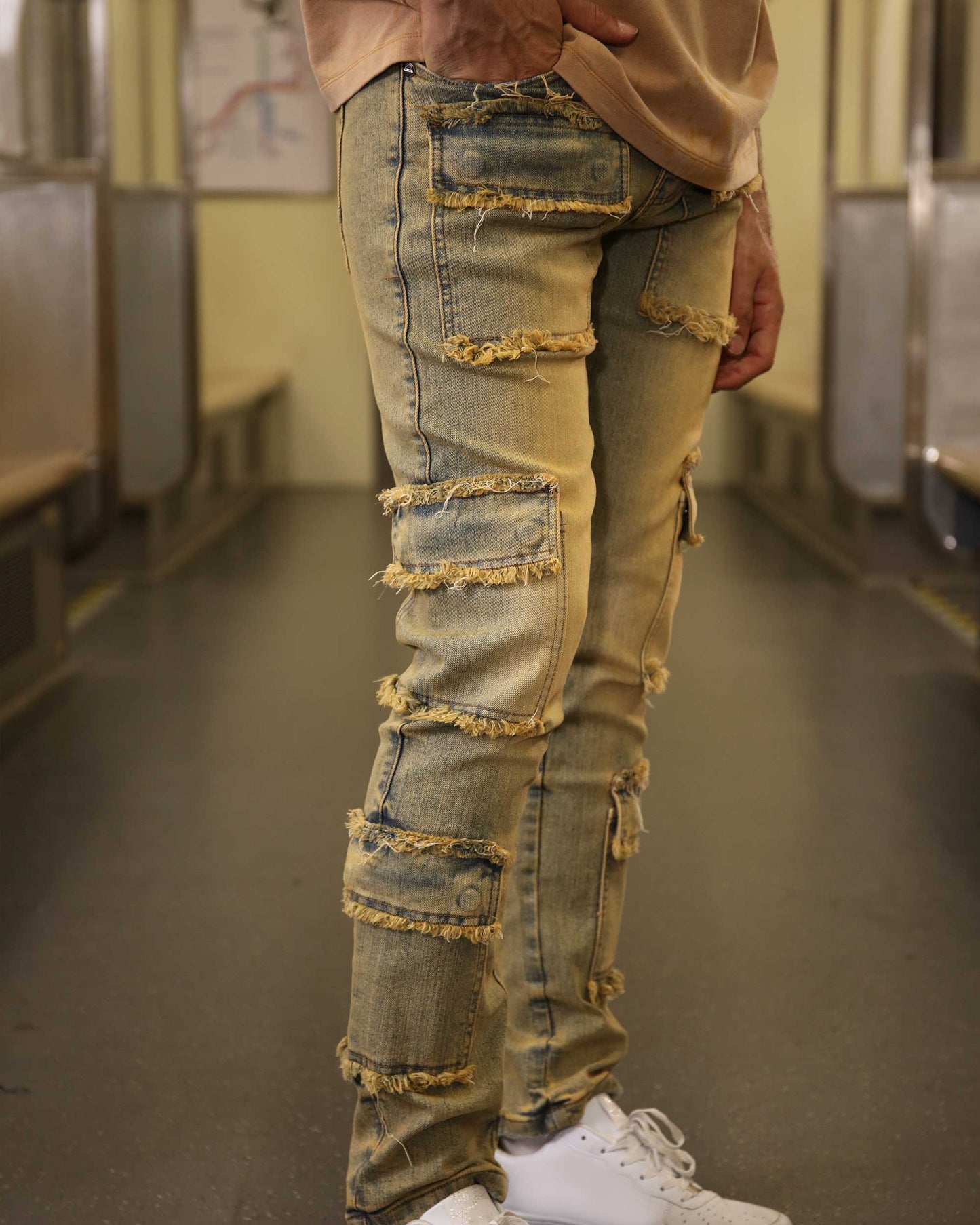 Logeqi raw edge brown jeans with distressed patches worn with white sneakers