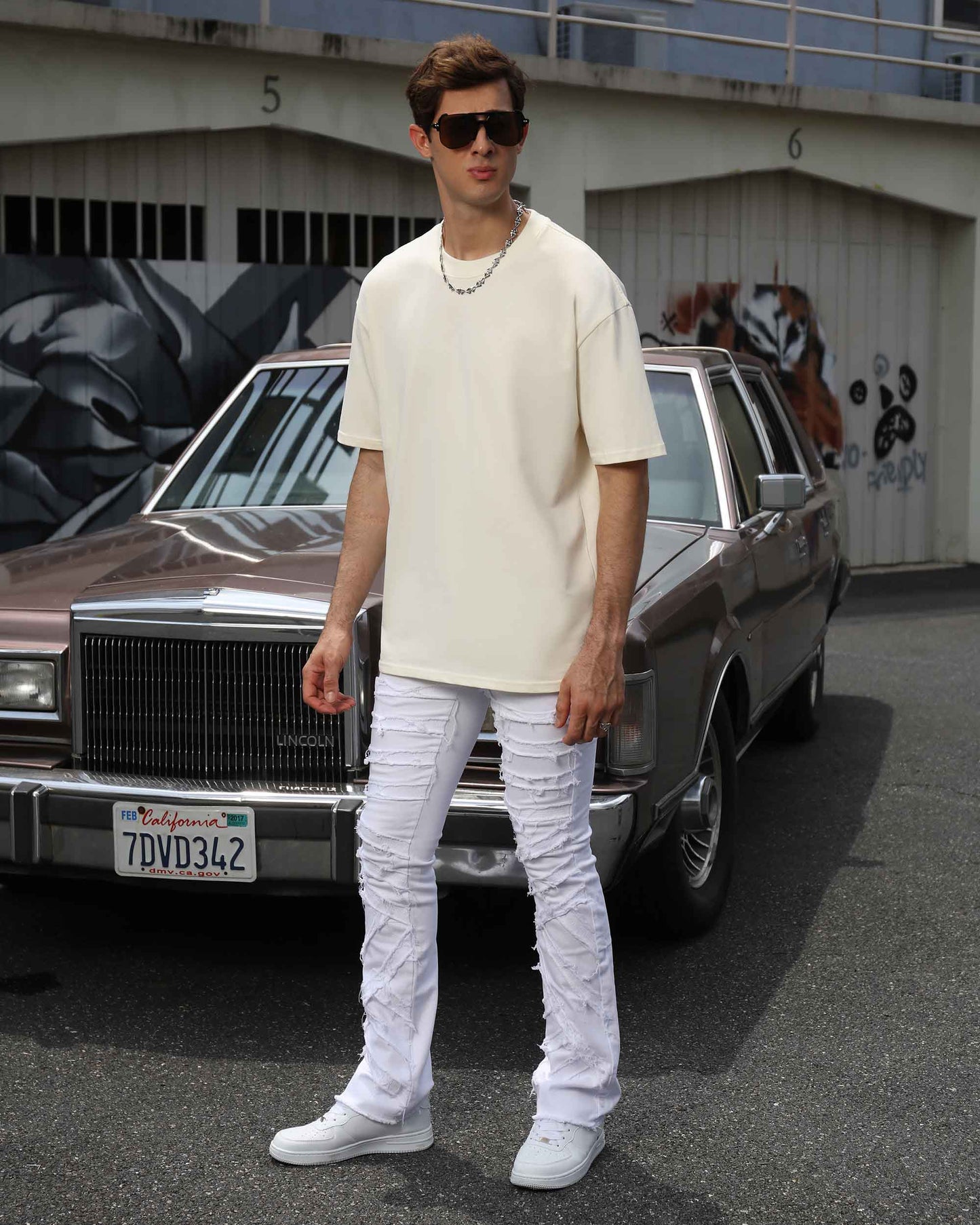 Logeqi retro white flared jeans featured on a model standing next to a vintage car