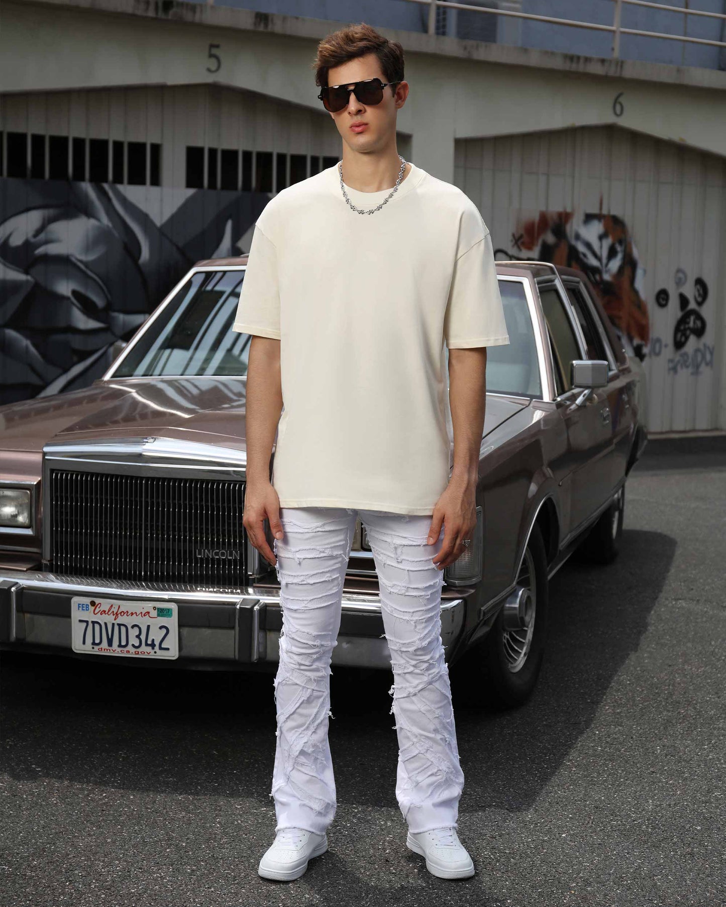 Model wearing Logeqi retro white flared jeans with stylish rips, paired with a casual oversized shirt