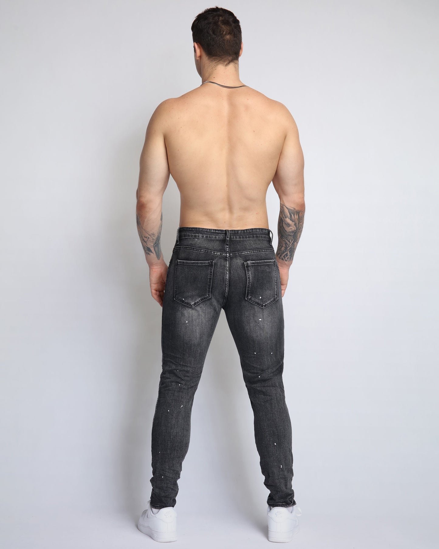 Stylish ripped black jeans for men by Logeqi, featuring a slim fit and detailed embellishments
