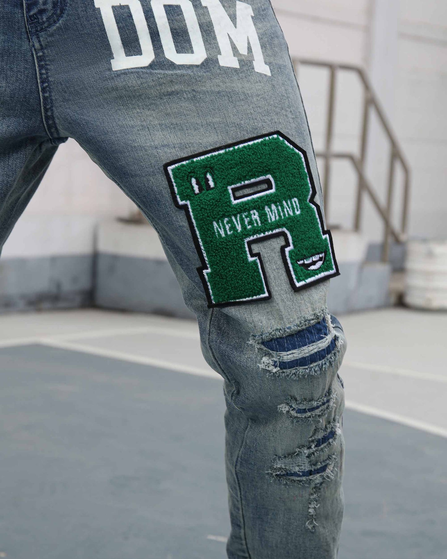 Logeqi ripped patchwork jeans featuring a green embroidered patch and distressed detailing