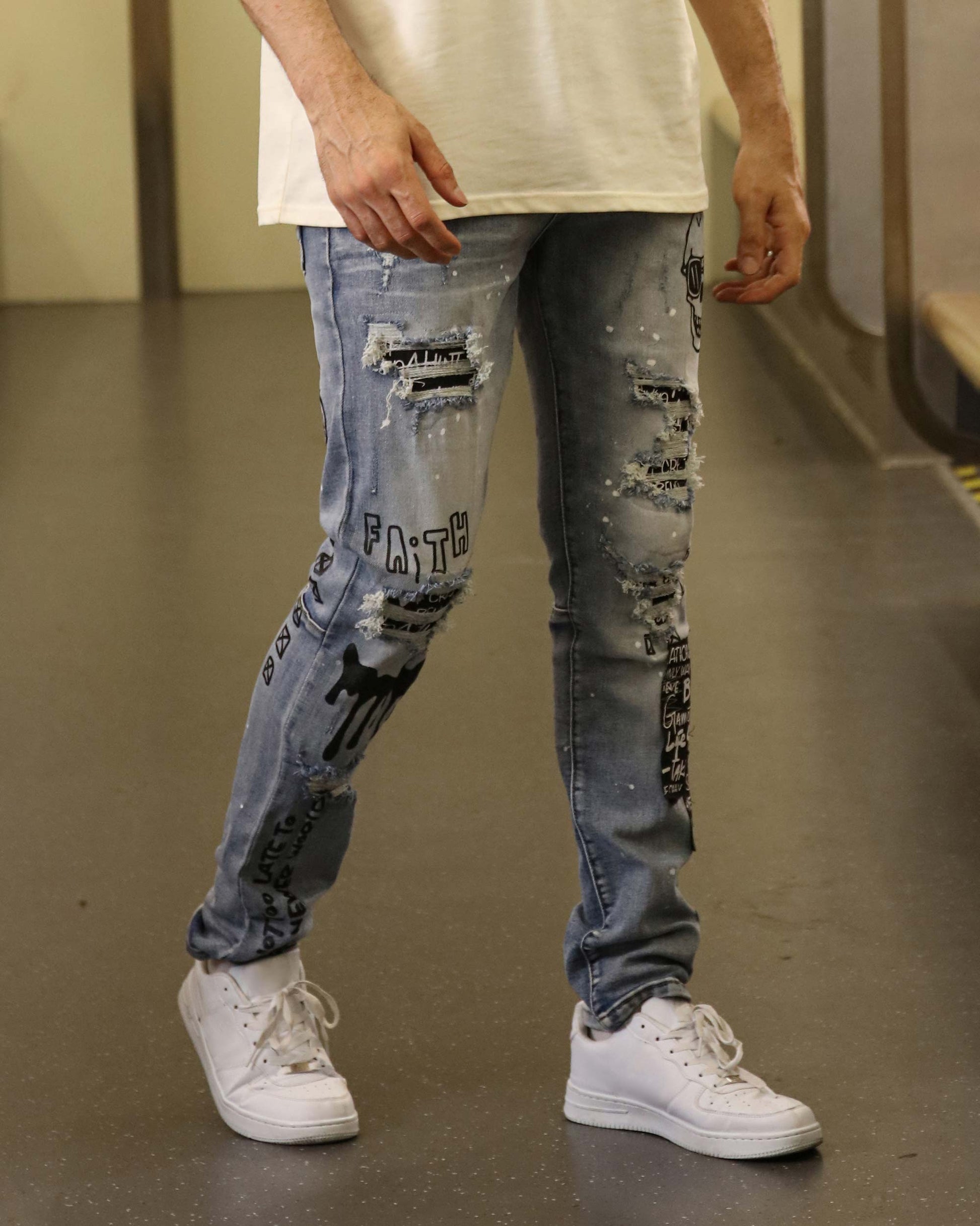 Logeqi skull graffiti ripped jeans worn by a model with white sneakers and a white shirt
