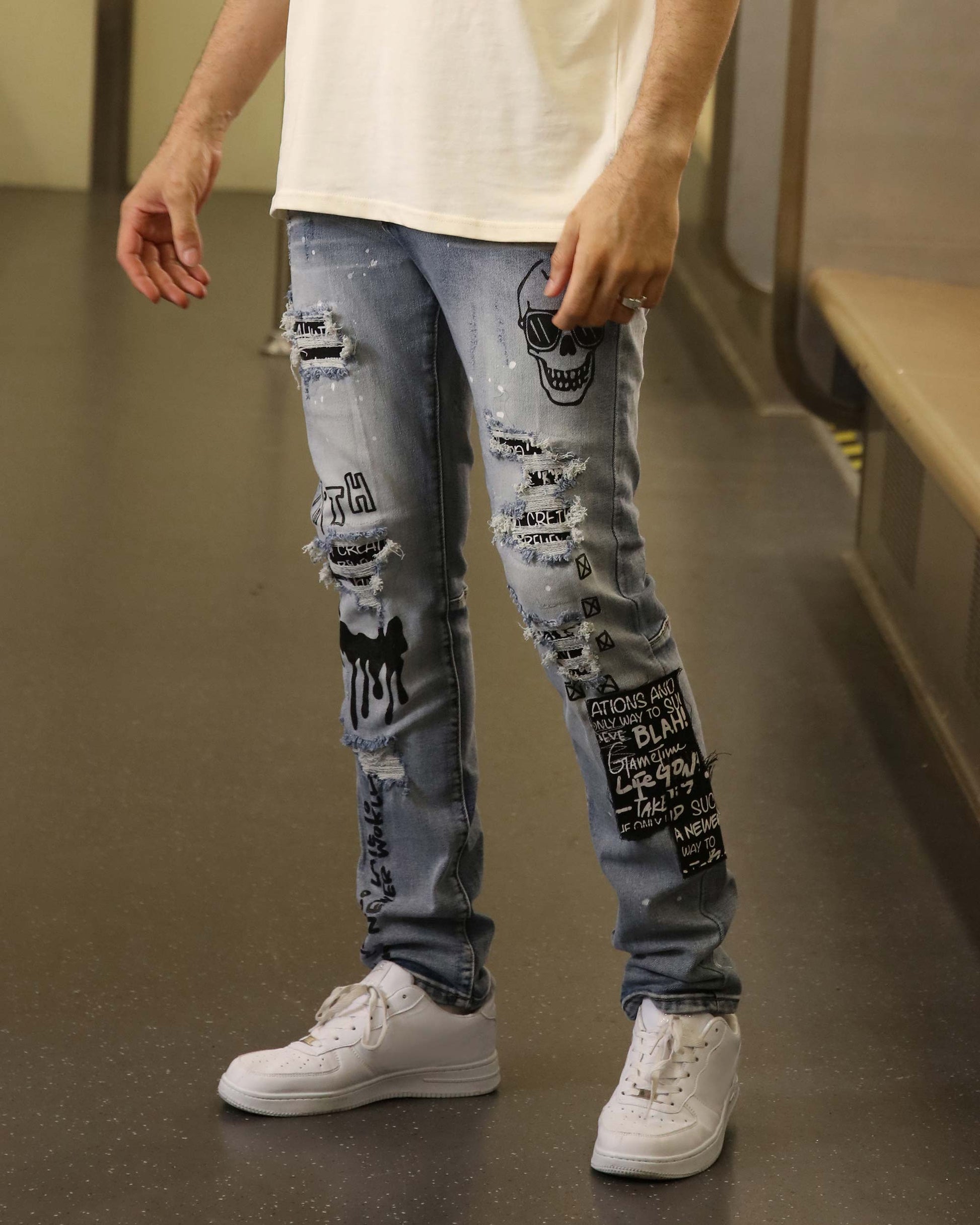 Logeqi skull graffiti ripped jeans in light blue with black graphic prints and distressed details