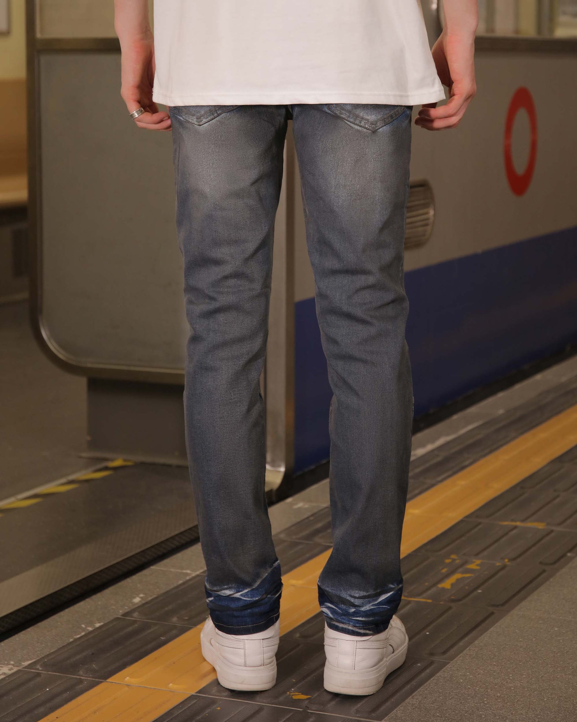Logeqi slim fit dark wash jeans shown on model from the back, styled with white sneakers
