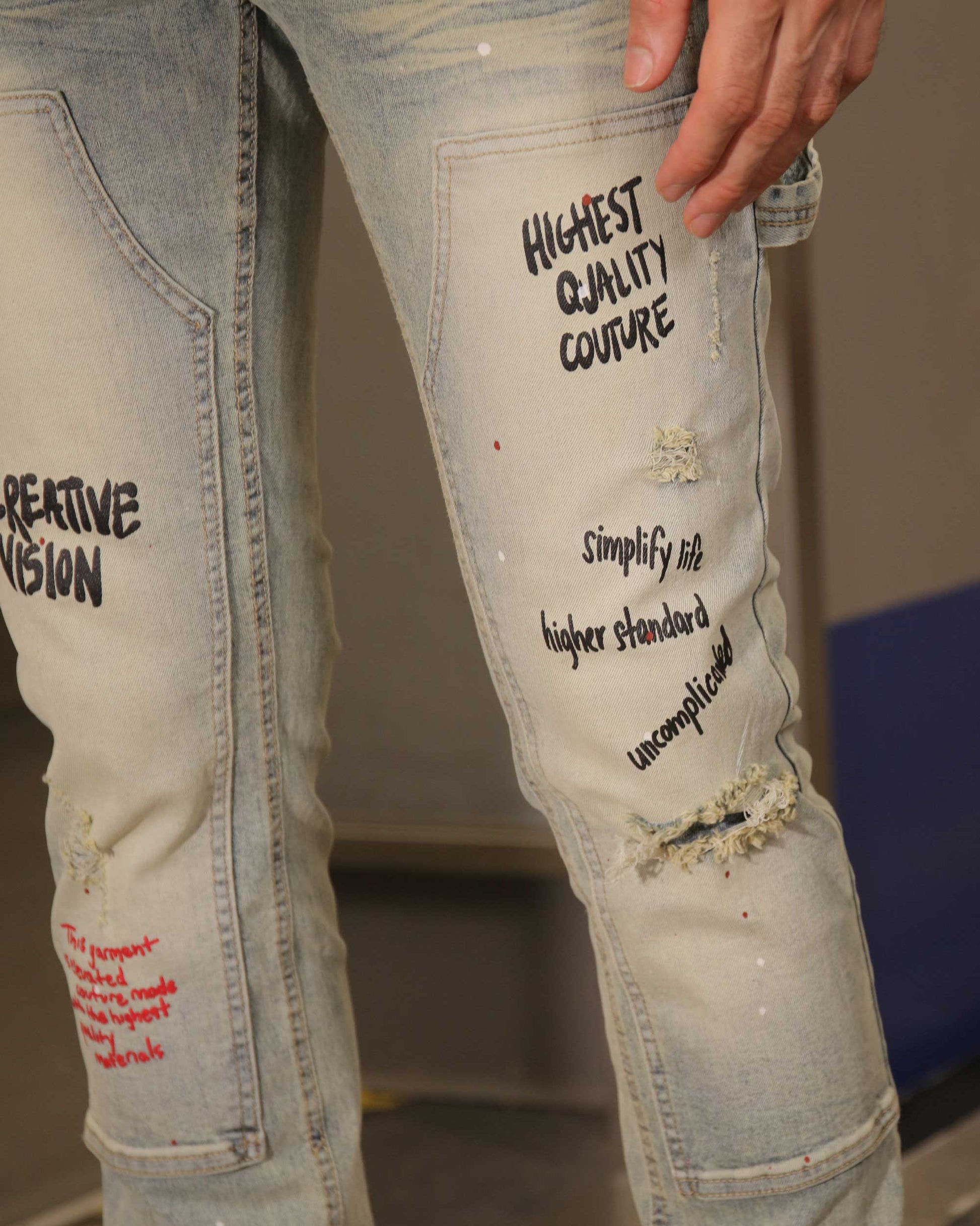 Logeqi spray paint graffiti jeans with distressed details and artistic text designs on light denim