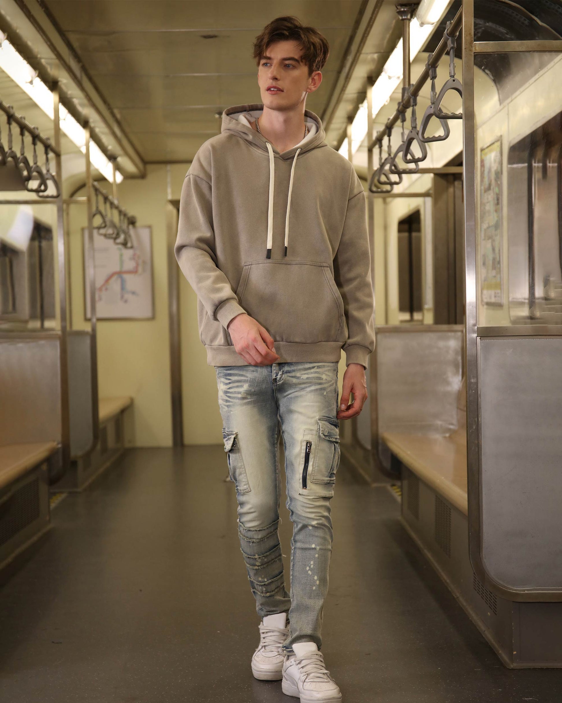Man wearing Logeqi spray painted blue cargo jeans with cargo pockets and white sneakers