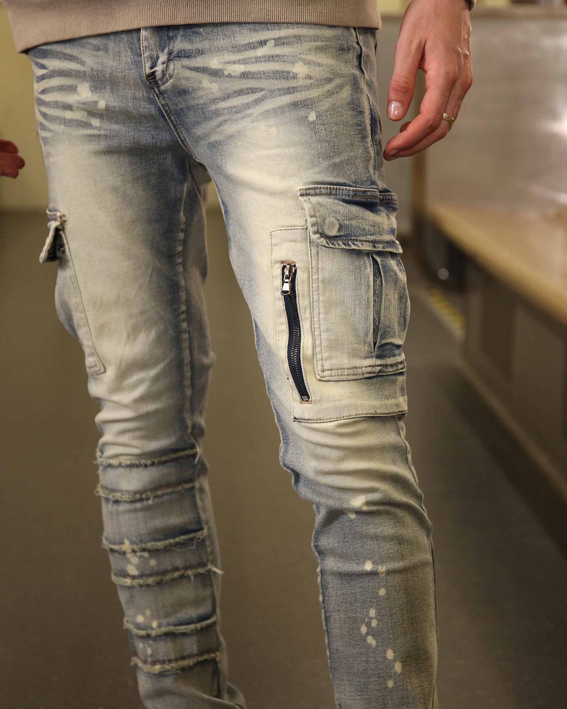 Logeqi spray painted blue cargo jeans with distressed details and zipper pockets on legs