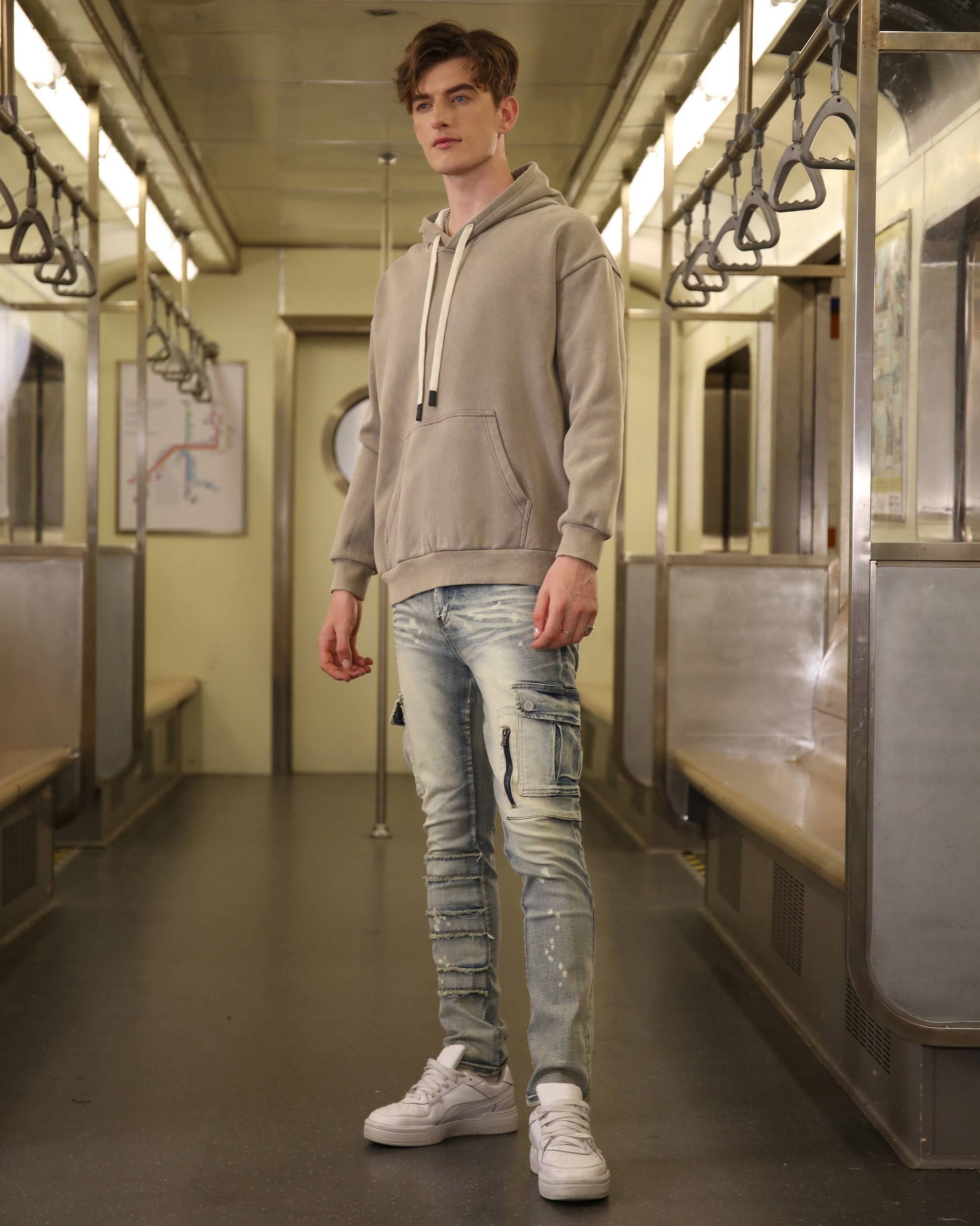 Logeqi spray painted blue cargo jeans worn by male model in casual subway setting