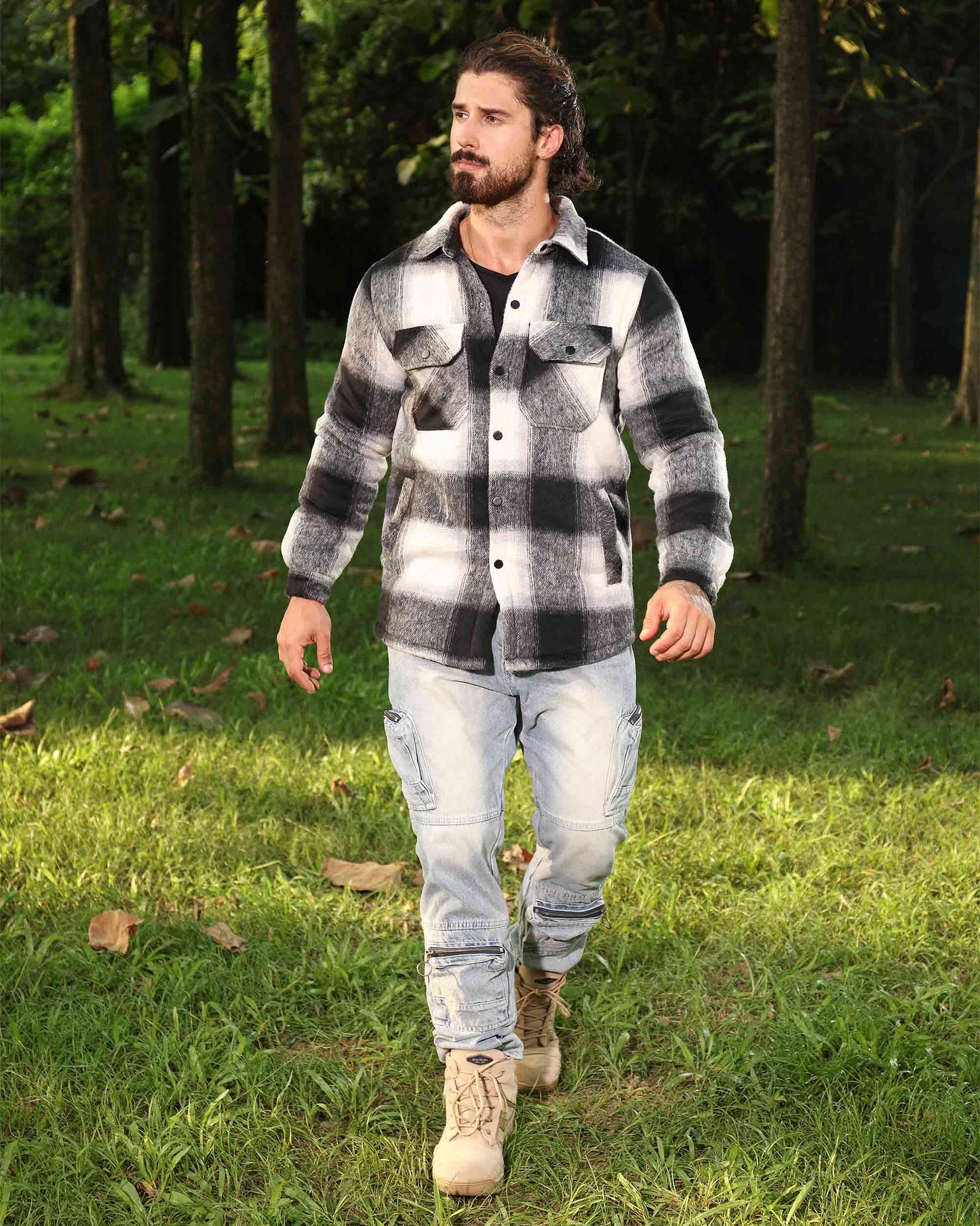 Man wearing Logeqi spring plaid jacket in black and white walking outdoors in forest setting