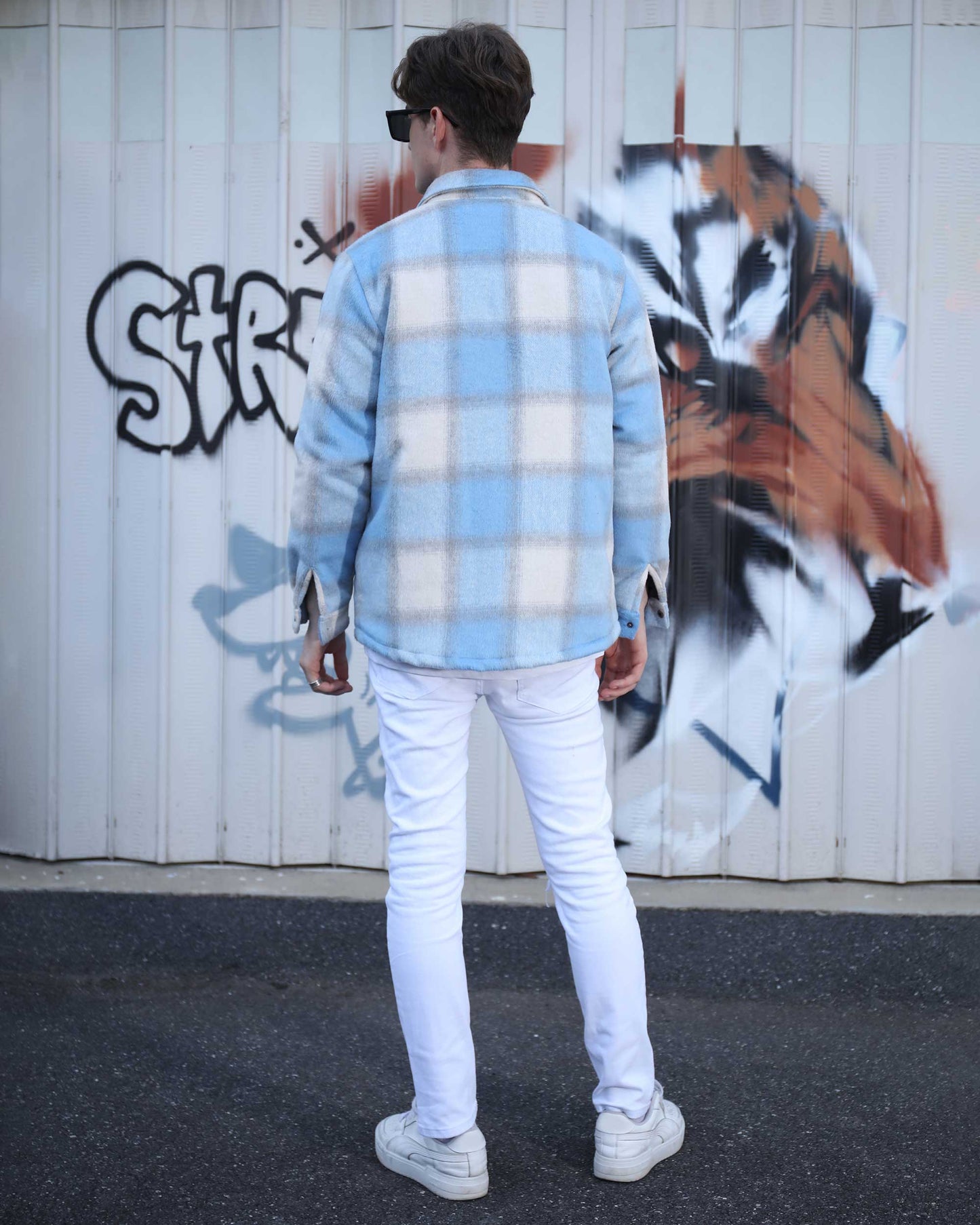 Logeqi spring plaid jacket in light blue and white worn by a man against graffiti wall