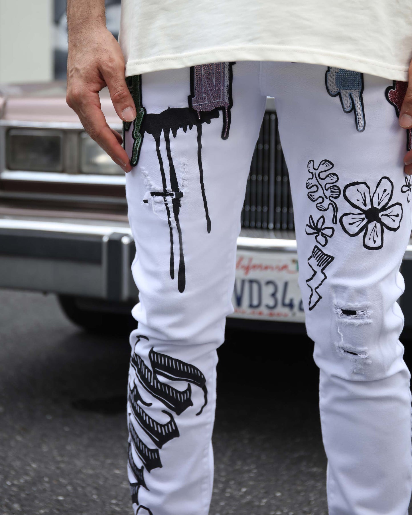 Logeqi streetwear graffiti jeans with unique designs and patches on a model in an urban setting