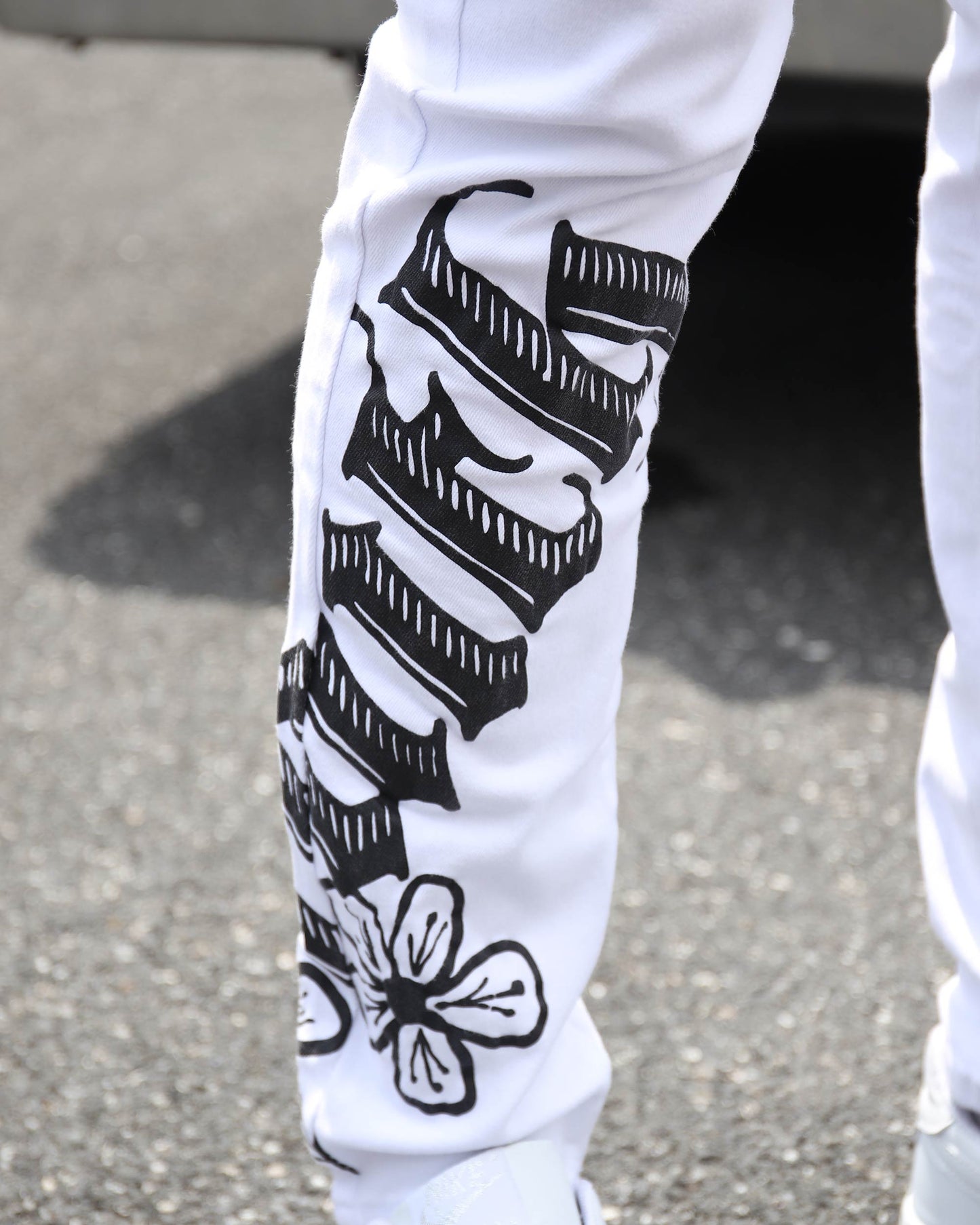 Logeqi streetwear graffiti jeans featuring bold black designs on white fabric